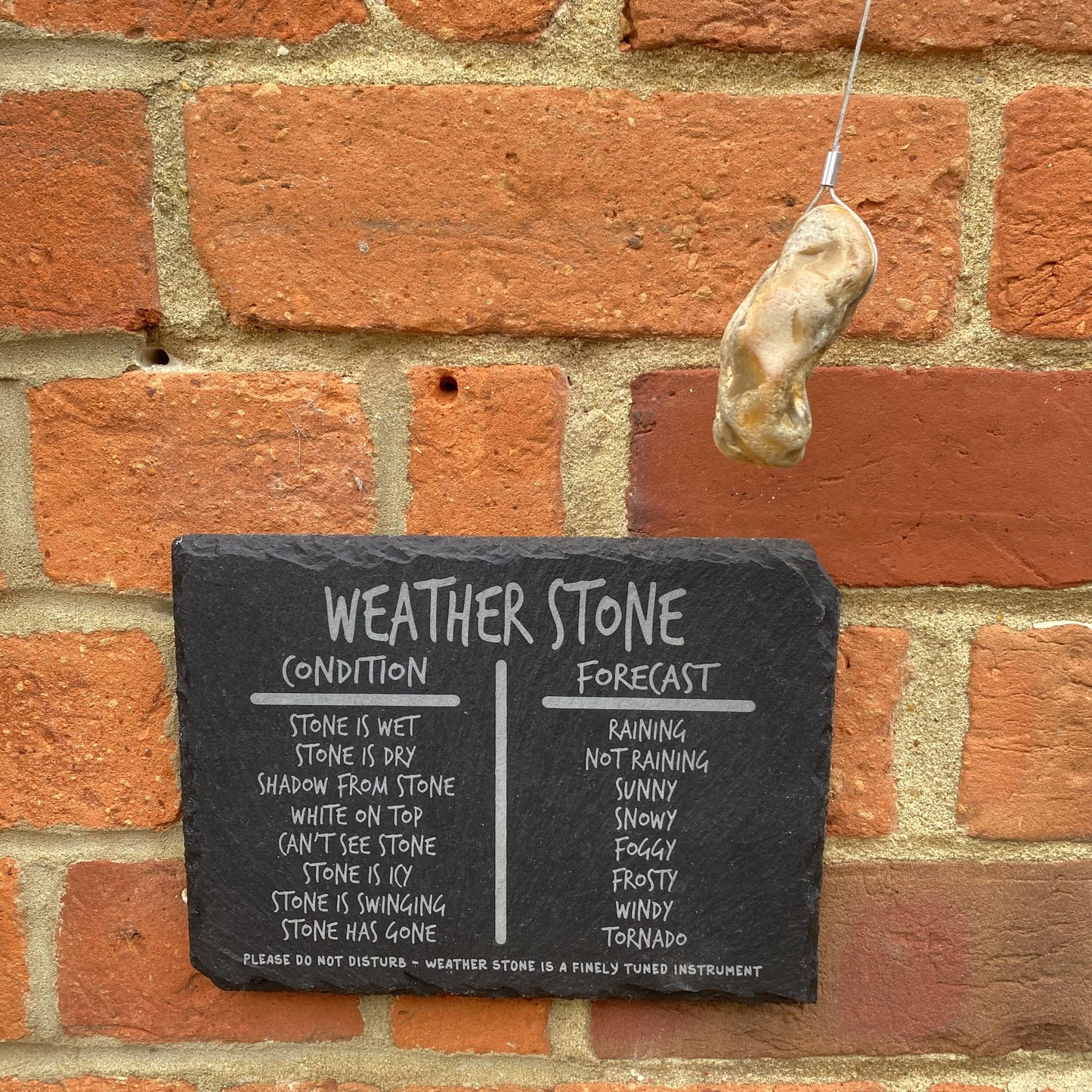 Slate plaque and hanging stone in windy outdoor conditions