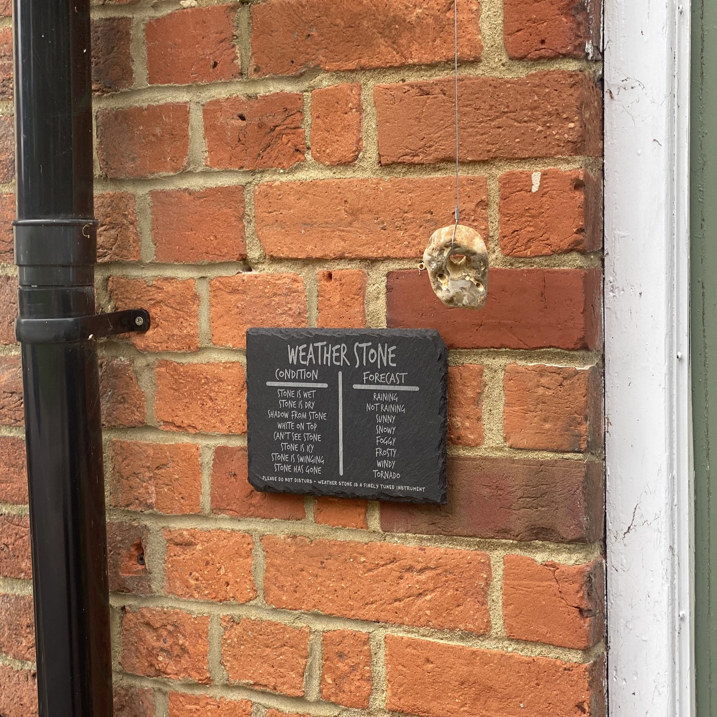 Wide view of hanging weather stone with house entrance edge for perspective