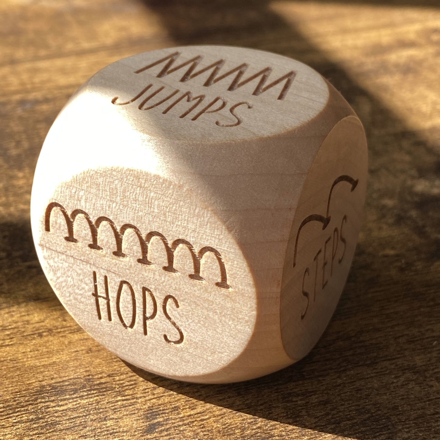 Close-up of Junior Exercise Decision Dice showing detailed engravings of movement prompts