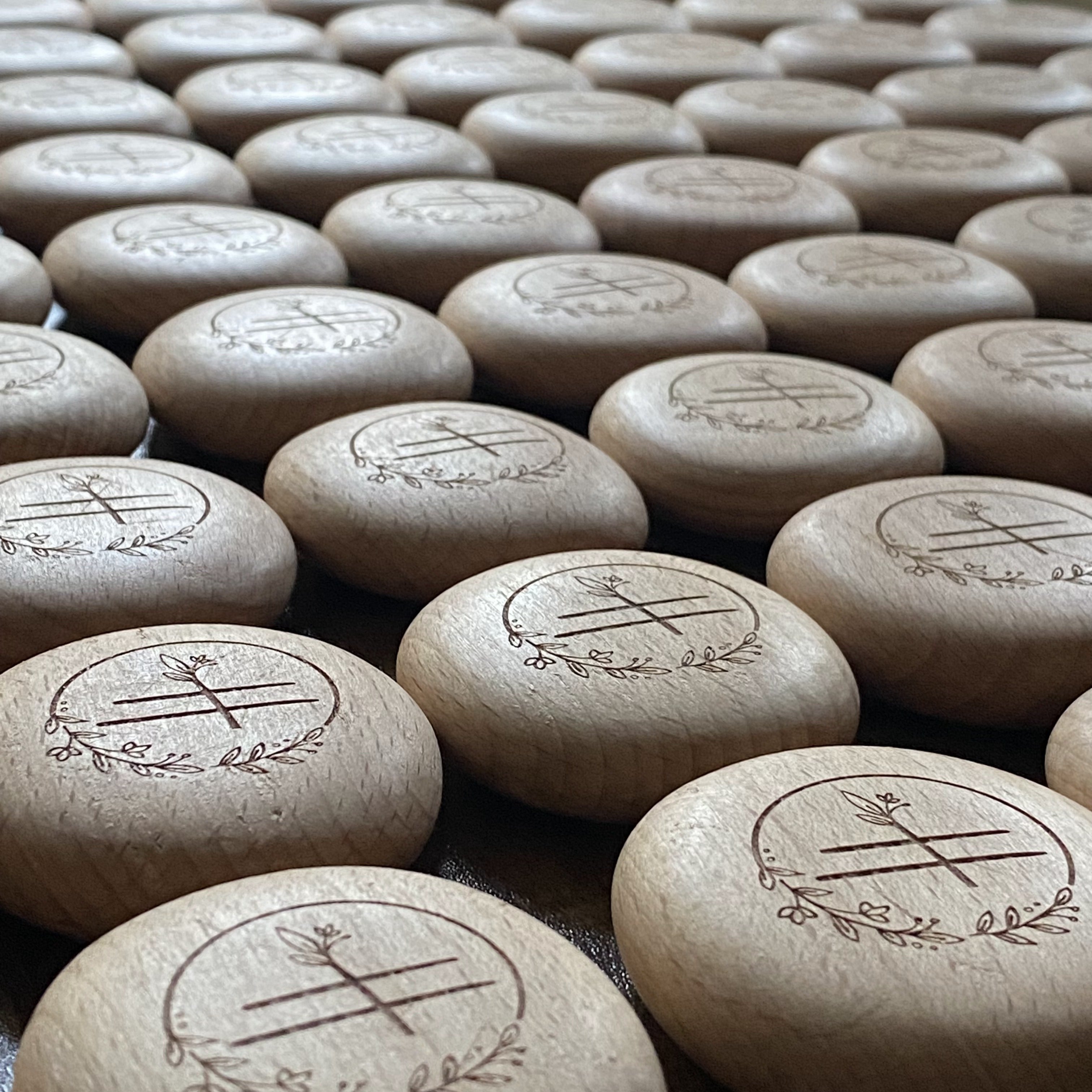 Production run of engraved wooden pebbles featuring nursery logo – bespoke branding elements for early years setting