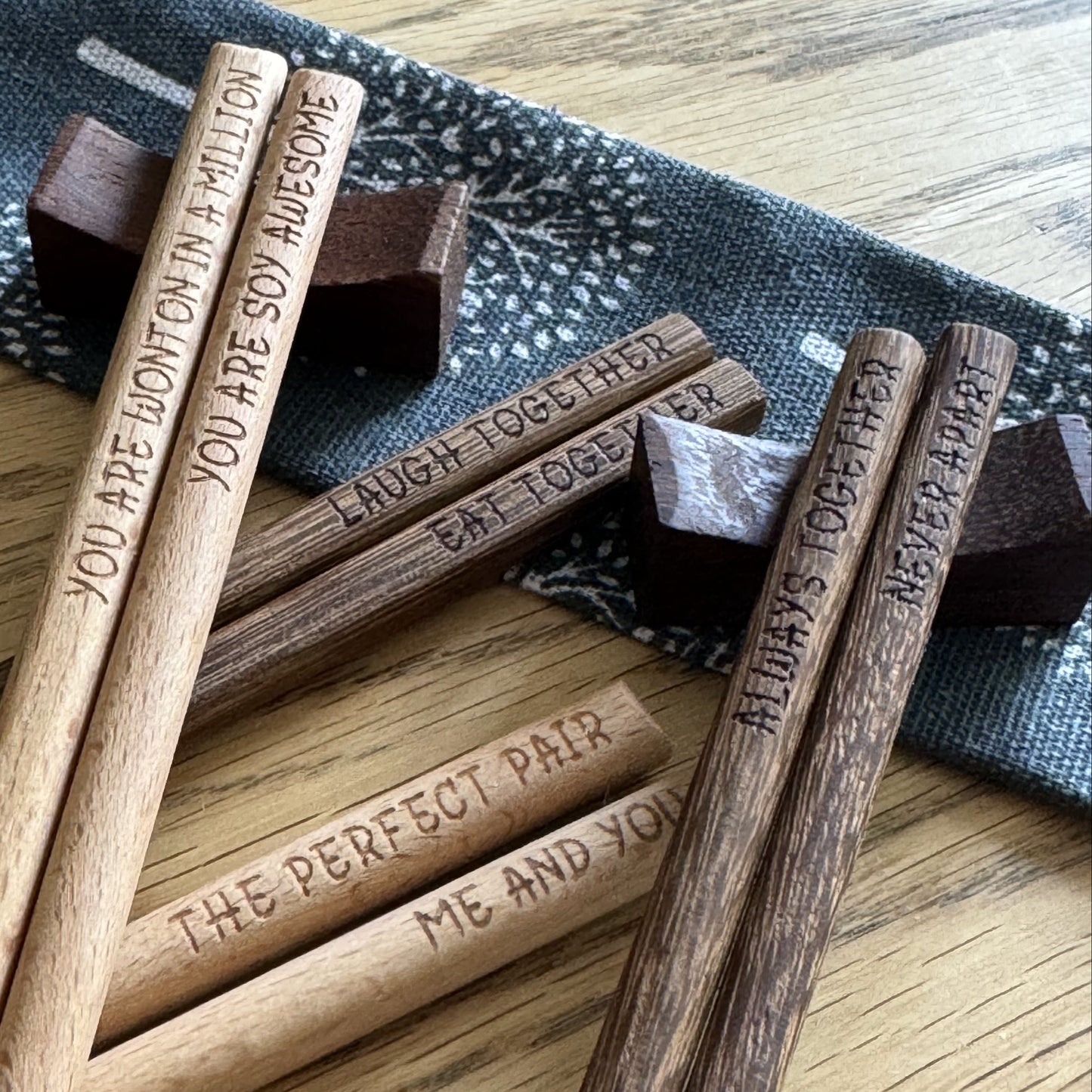Scattered chopstick sets, two pairs resting on wooden rest stands