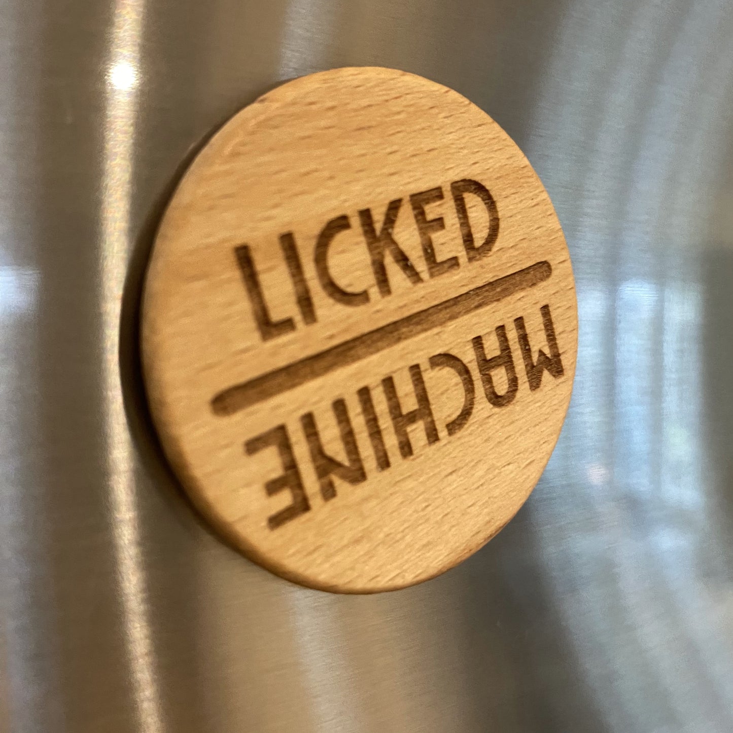 Funny dishwasher reminder dial reading “Licked” and “Machine” – magnetic mounted on appliance for everyday clarity.