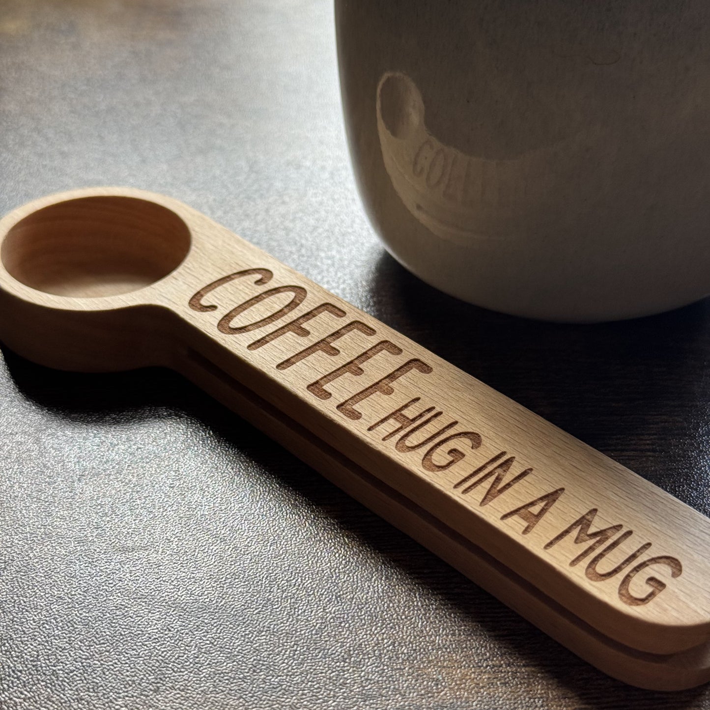 Engraved Hug in a Mug coffee spoon resting in front of a mug – thoughtful gift idea