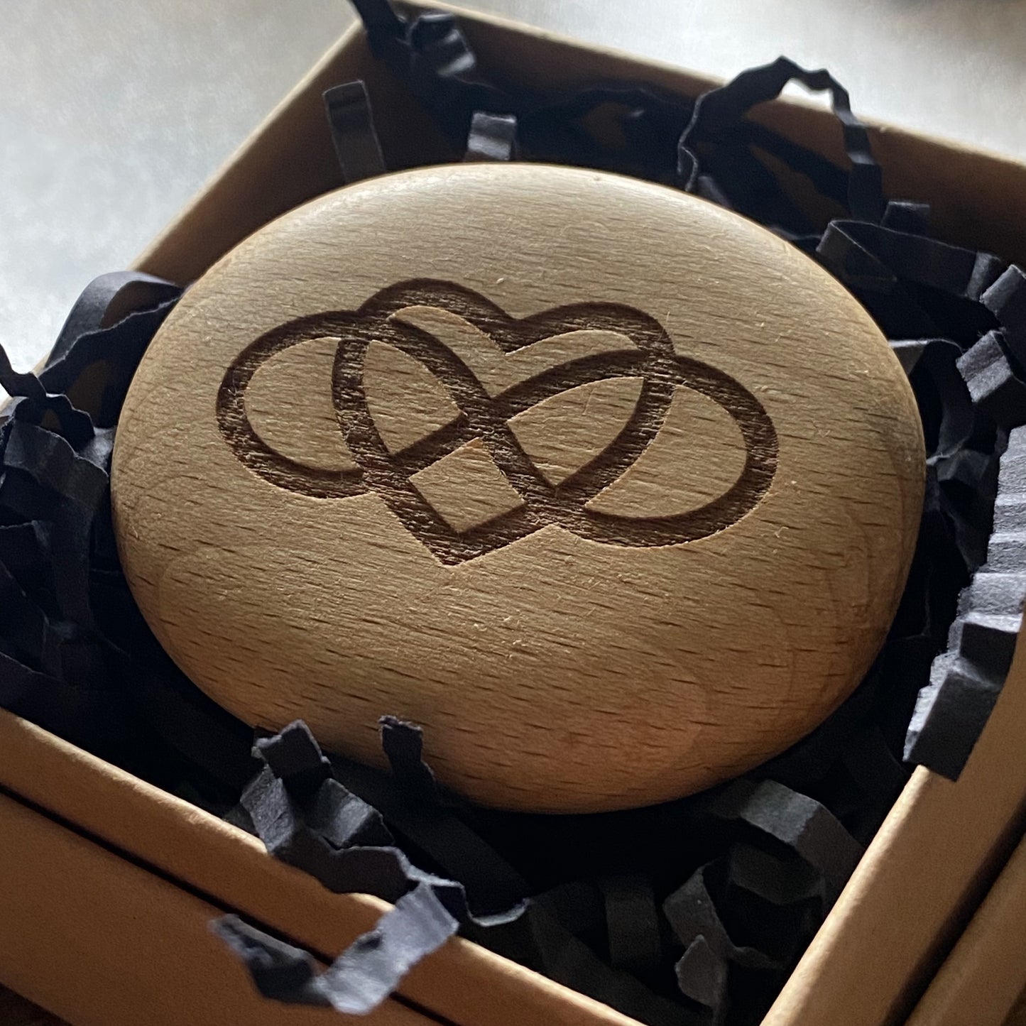 Infinity loop interlocked in a heart wooden pocket pebble – symbol of lasting love and connection, displayed in gift box