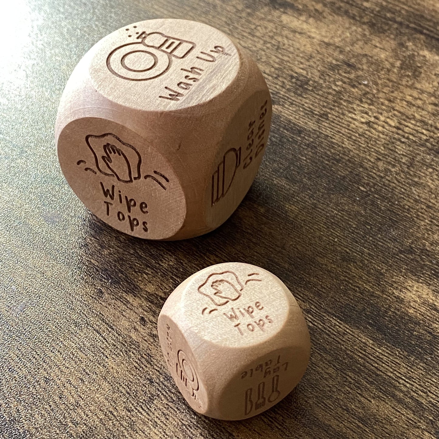 Pocket and jumbo sizes of Junior Chores Decision Dice shown side by side, featuring engraved kid-friendly chore illustrations
