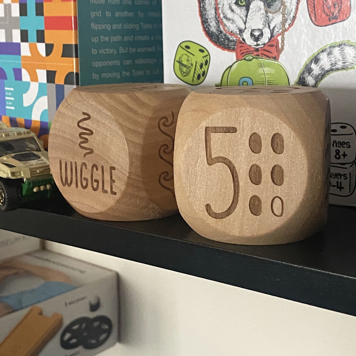 Pair of Junior Exercise Decision Dice on shelf featuring "five" and "wiggle" movement engravings