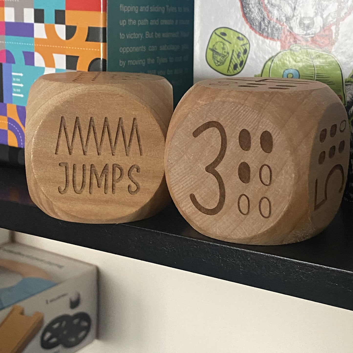 Two Junior Exercise Decision Dice displayed on shelf with clear "three" and "jumps" engraved prompts