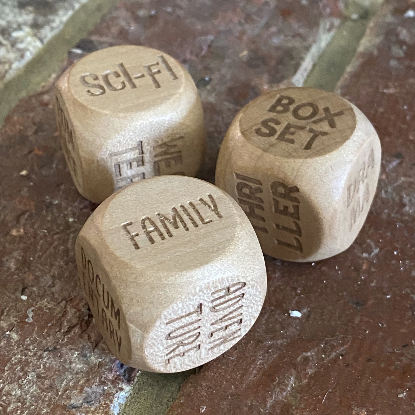 Movie Night Decision Dice set placed on hearth, showing detailed engrave and designs for viewing genres