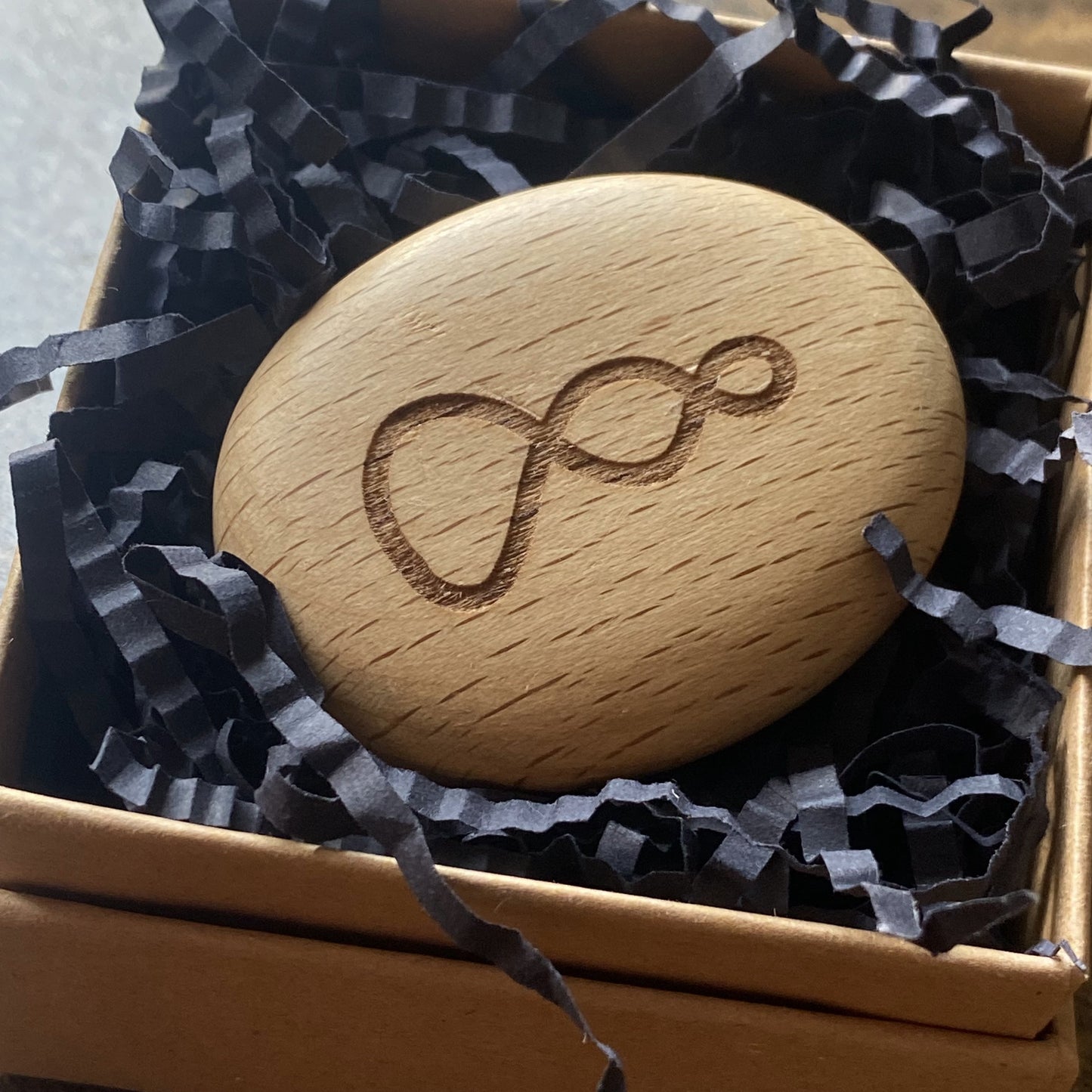 Pikorua Twist symbol on wooden pocket pebble – Māori representation of connectedness, shown in gift box