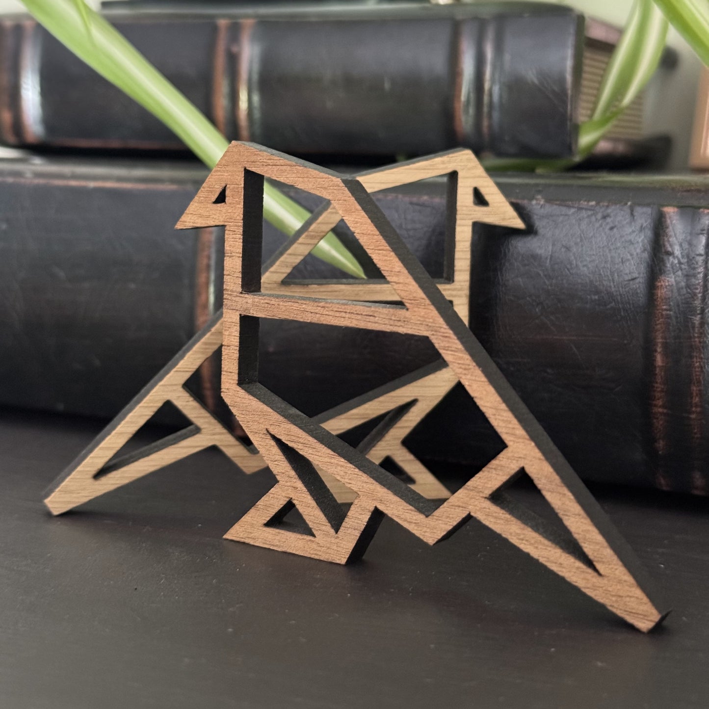Origami-style wooden bird pair displayed on a shelf, perched on a stack of books for modern decor