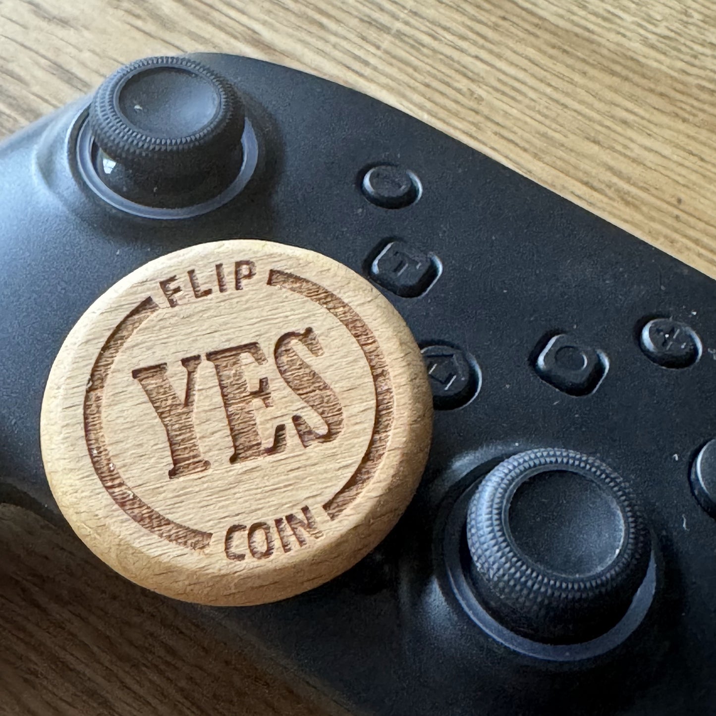 Yes No Ultimate Flip Coin resting on a games controller – fun gaming decision maker