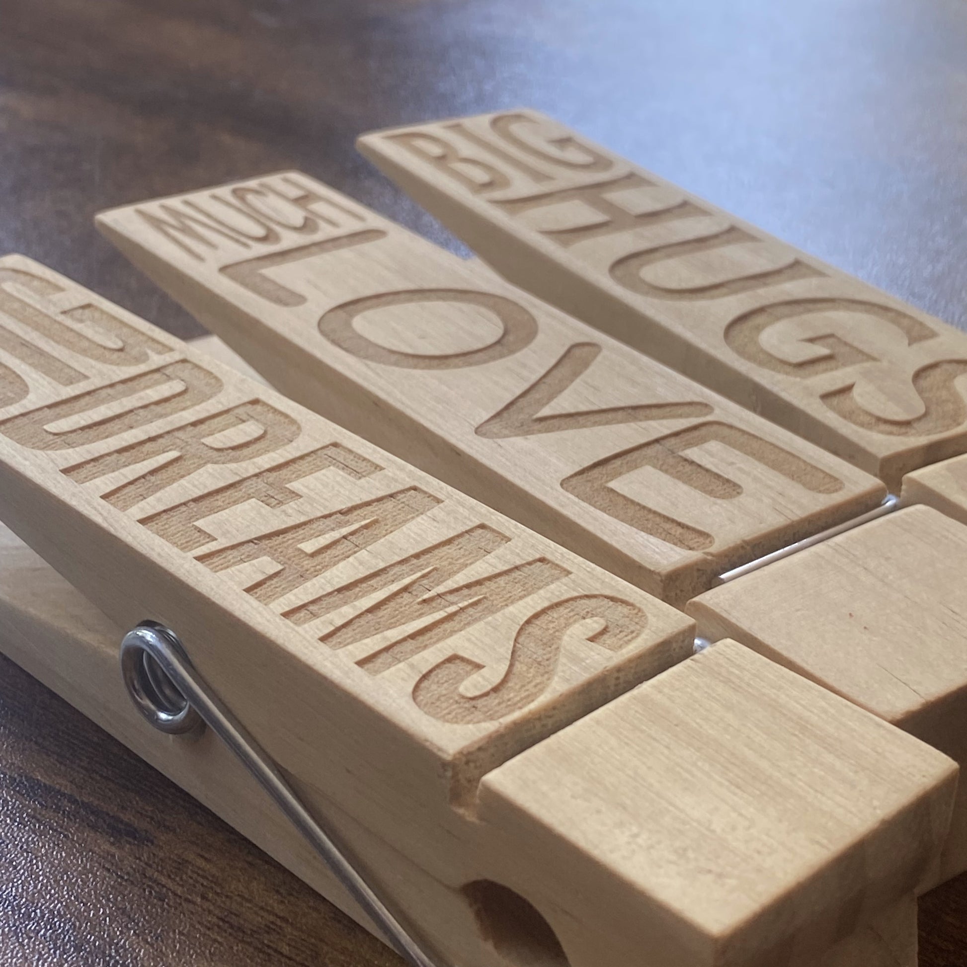 A stylish view of three oversized wooden Jumbo Pegs displaying artwork, notes, and reminders.