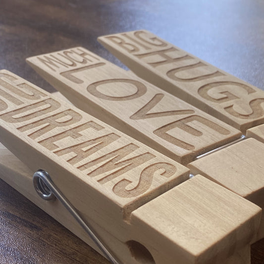 A stylish view of three oversized wooden Jumbo Pegs displaying artwork, notes, and reminders.