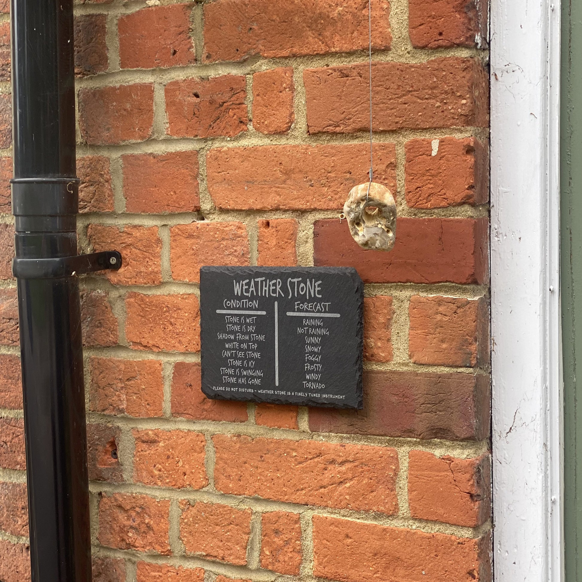 Wide view of hanging weather stone with house entrance edge for perspective