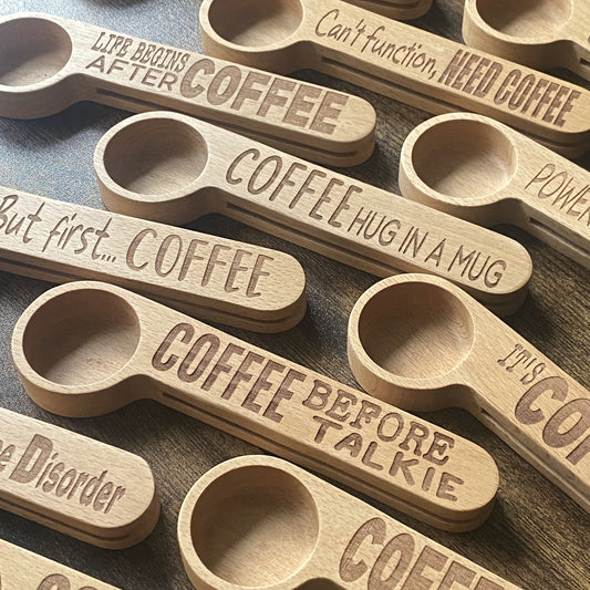 A collection of beautifully engraved wooden coffee spoons, showcasing different designs and quotes.