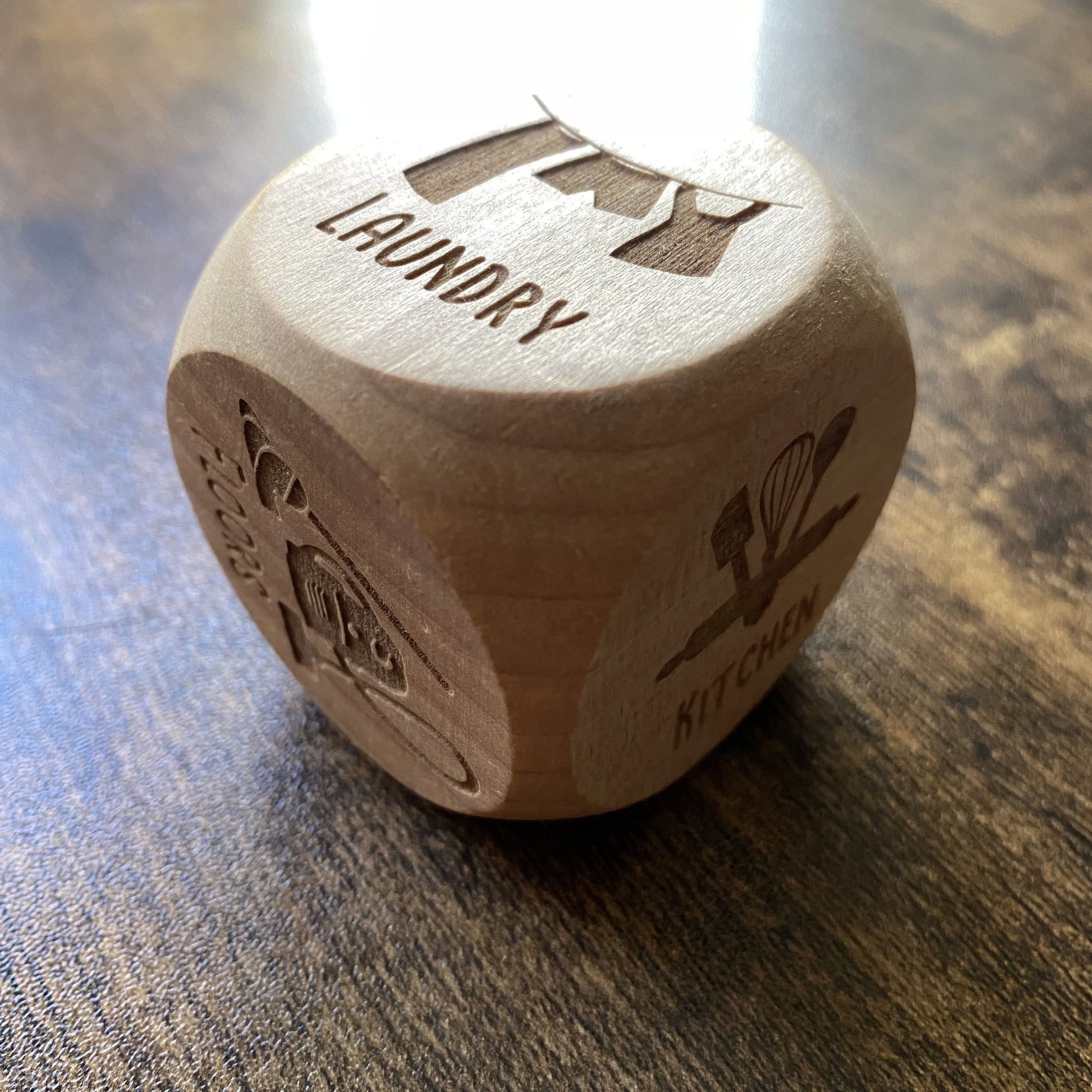 Angled close-up of engraved wooden Household Chores Decision Dice, showcasing detailed task lettering and smooth polished edges