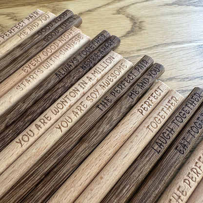 Angled lineup of chopsticks showing varied engravings.