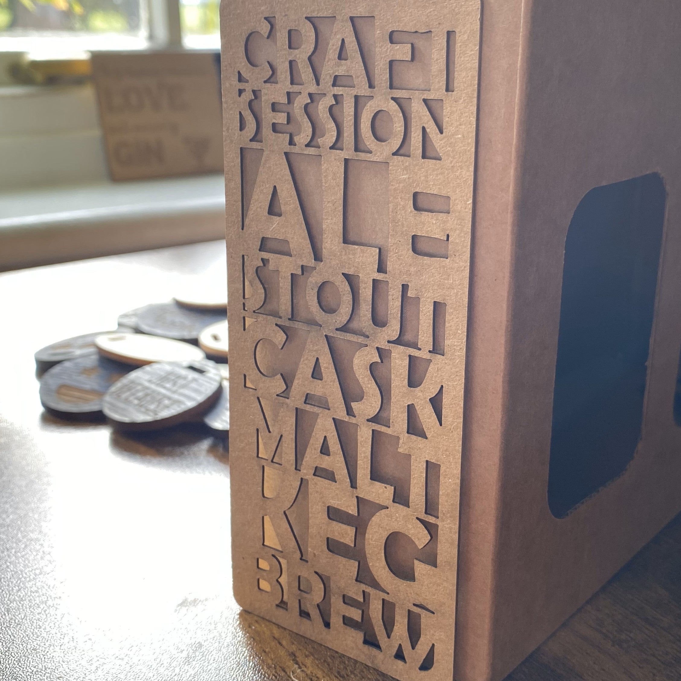 Prototype cardboard beer box packaging with engraved details, designed for secure and stylish transport