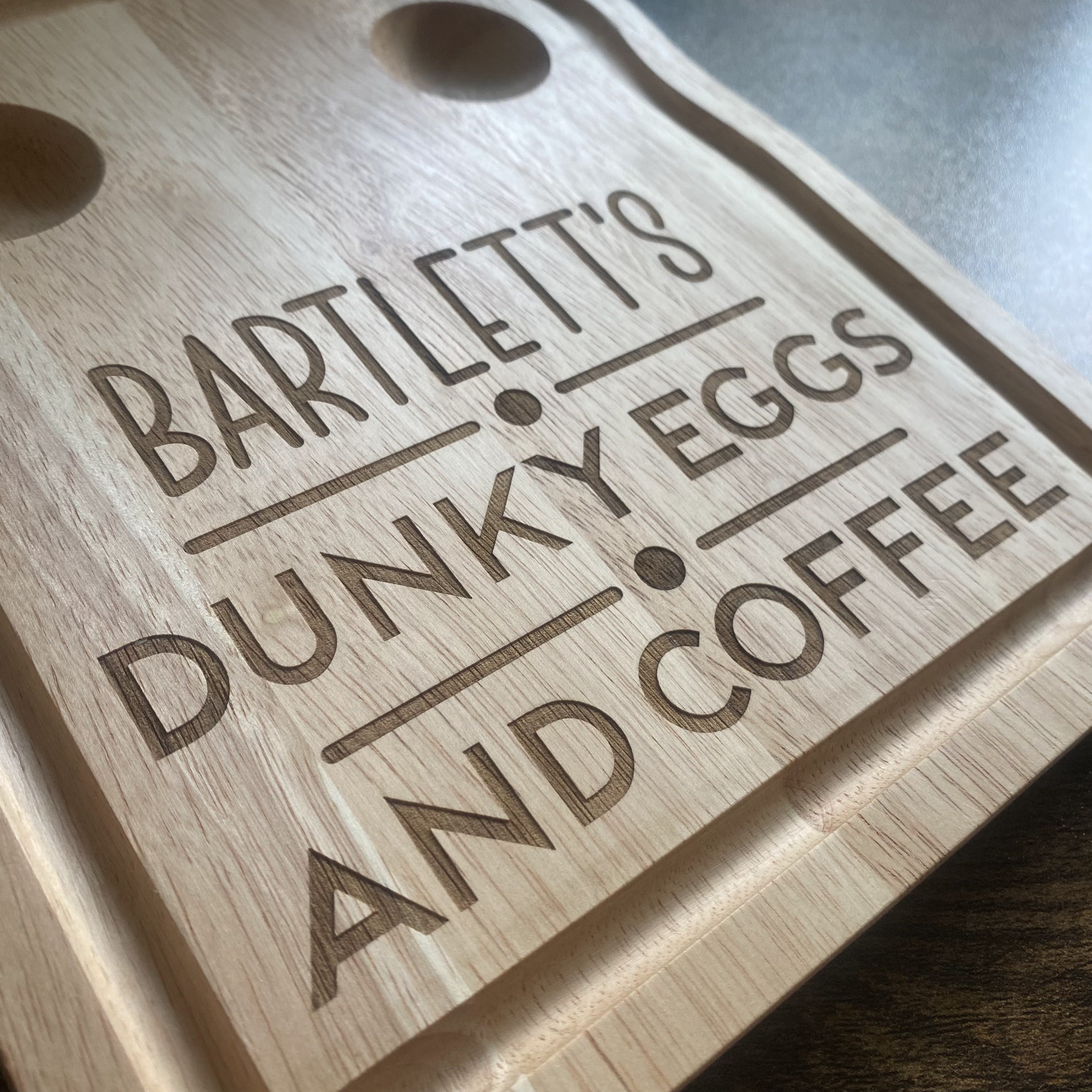 Angled close-up of bespoke engraved wooden breakfast board designed for serving eggs