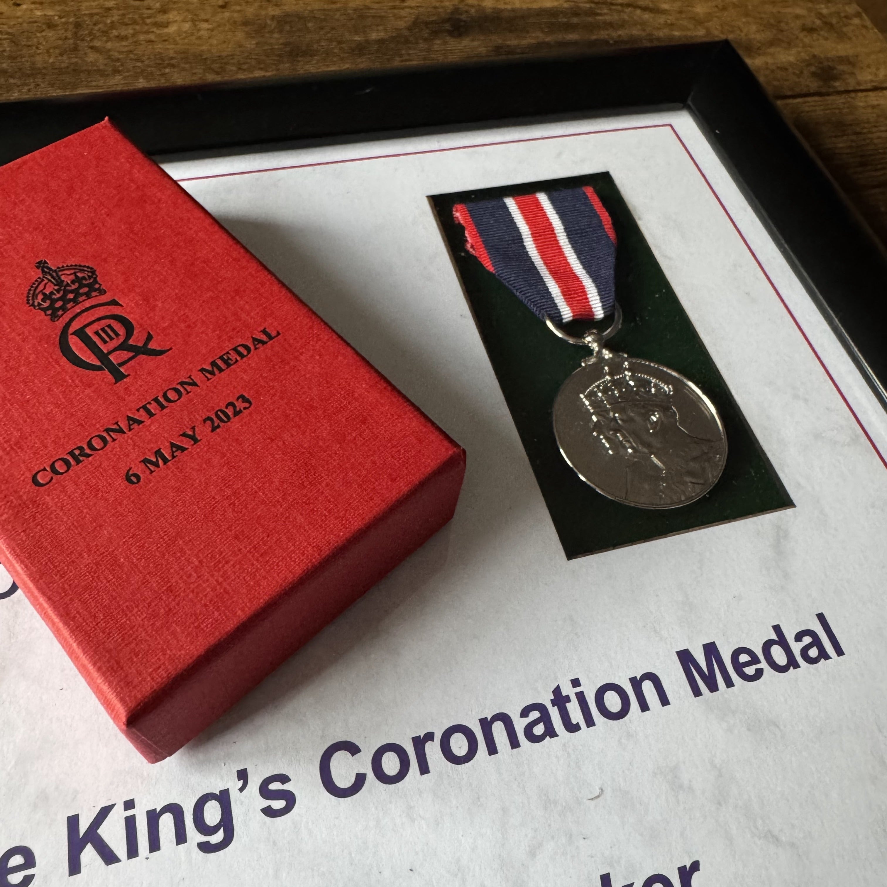 Custom framed commemorative medal displayed in a bespoke wooden frame, ideal for awards and special tribute
