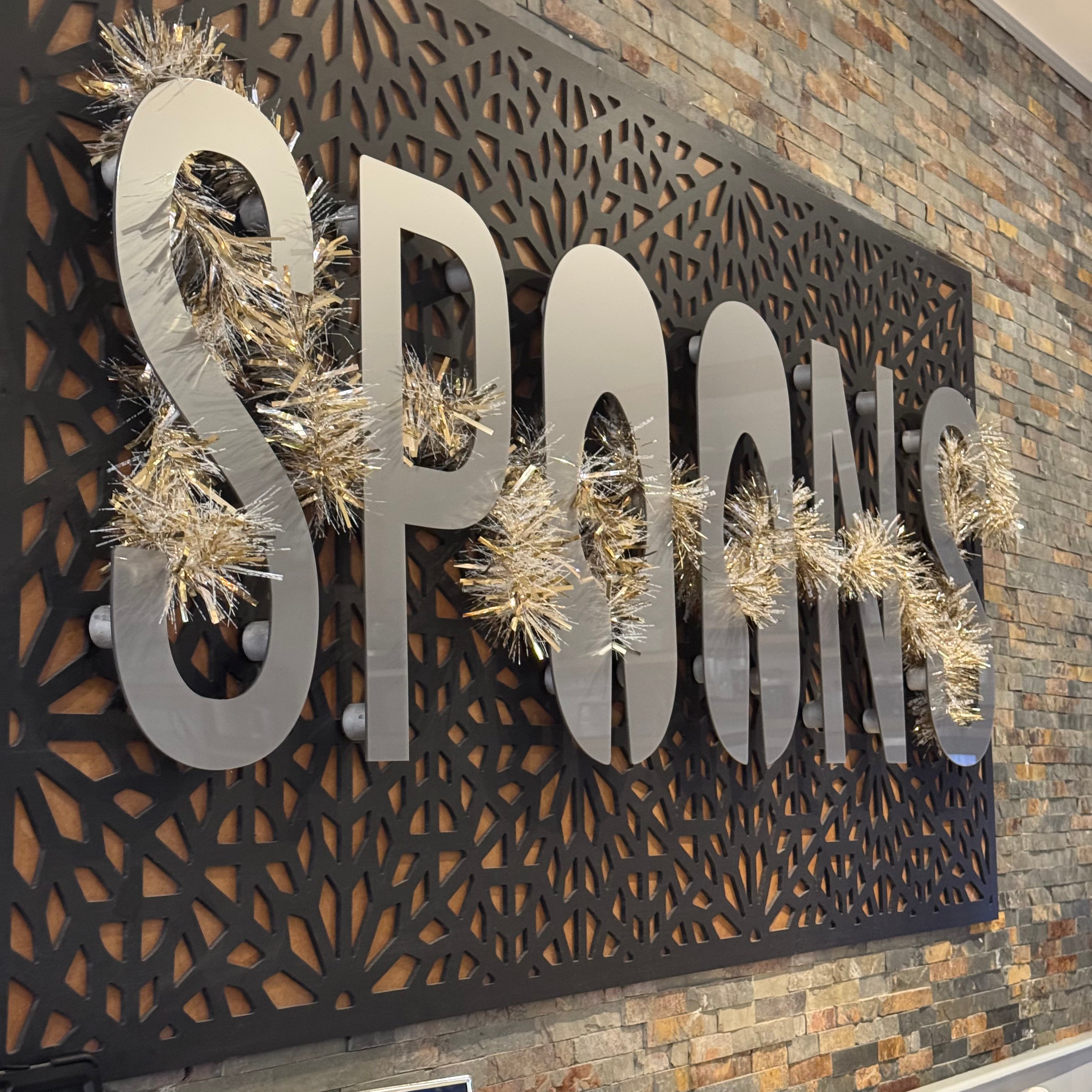Commercial sign featuring bespoke logo lettering by In the Oaks, decorated with festive tinsel