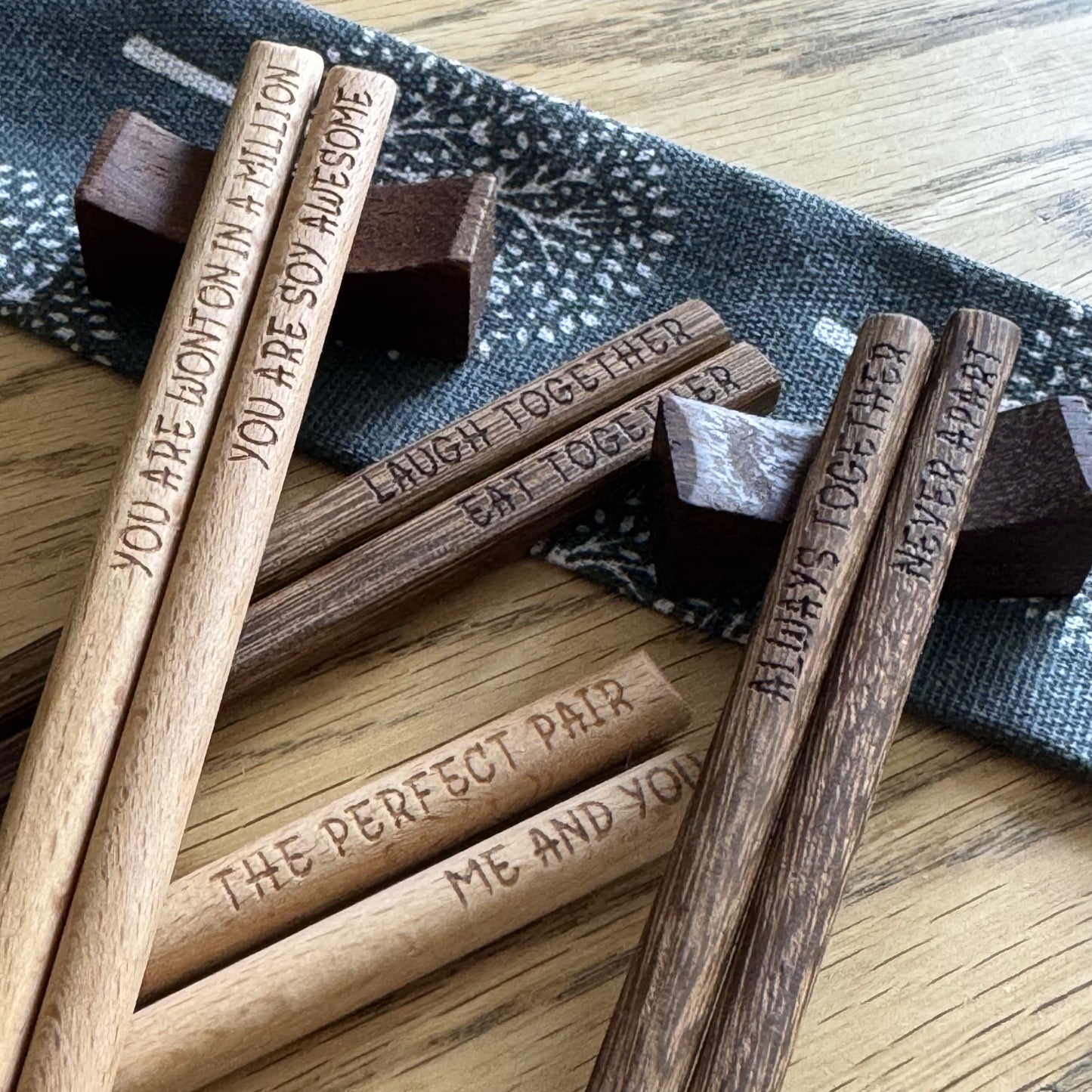Scattered chopstick sets, two pairs resting on wooden rest stands