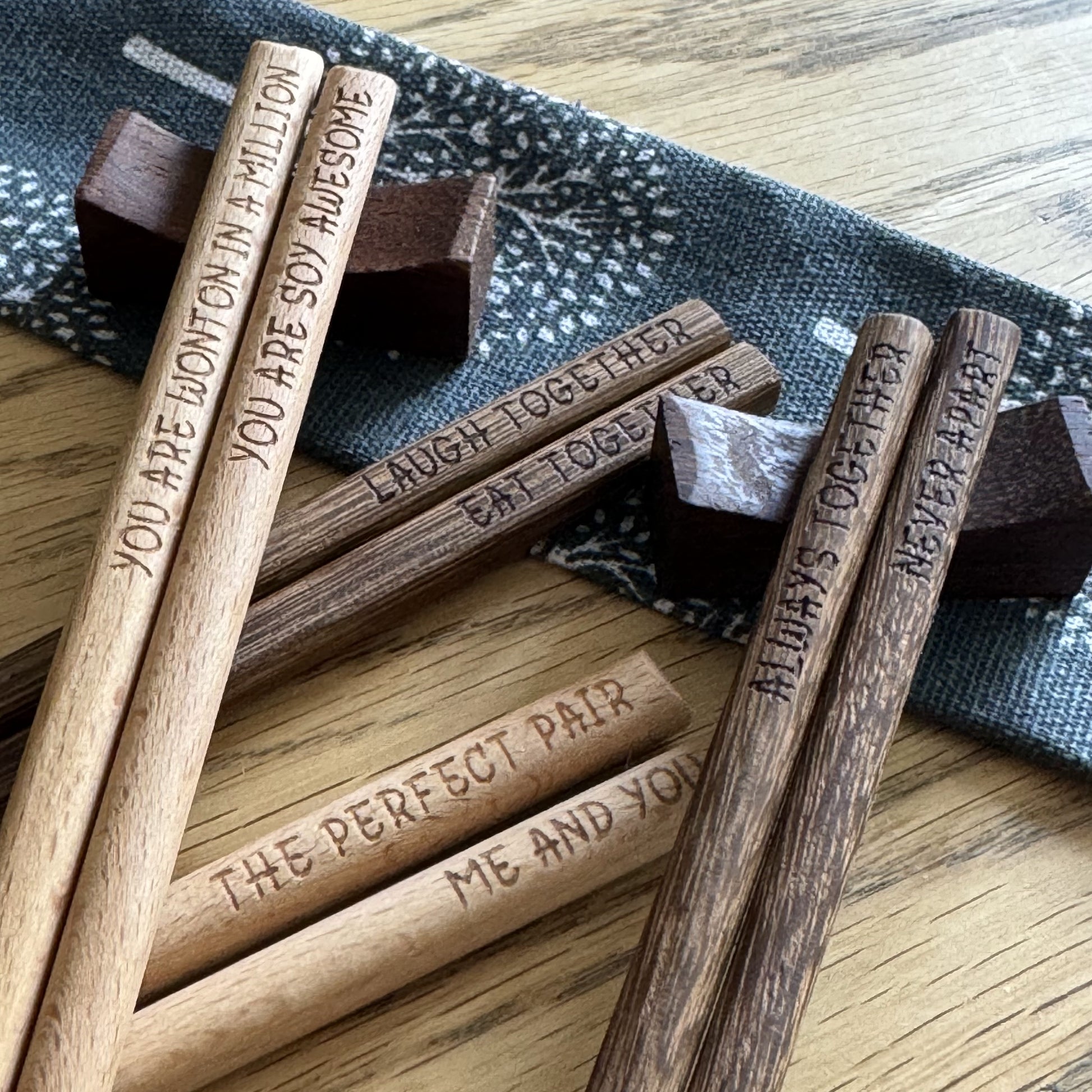 Scattered chopstick sets, two pairs resting on wooden rest stands