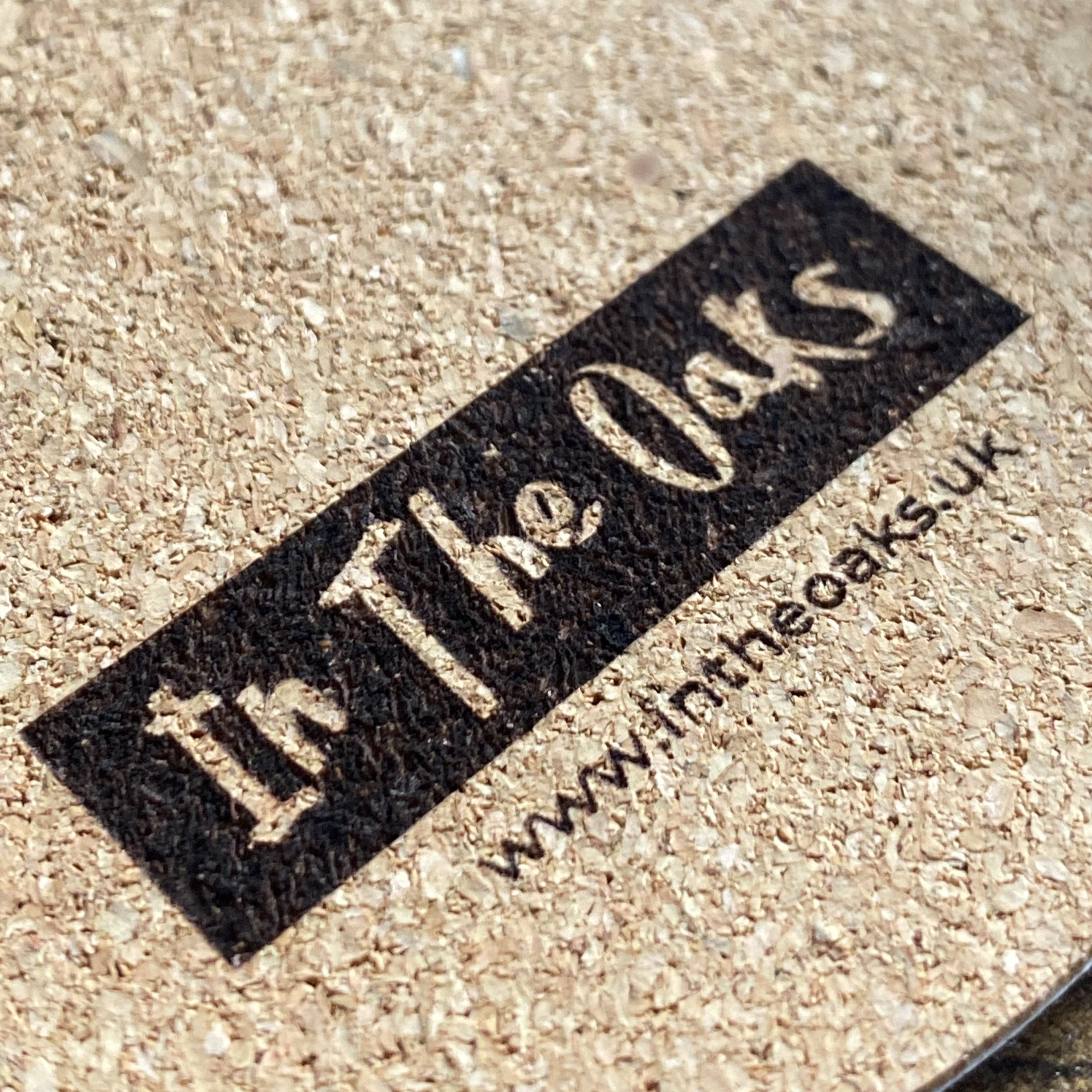 Close-up of branded laser engraving on cork material, showcasing detailed craftsmanship