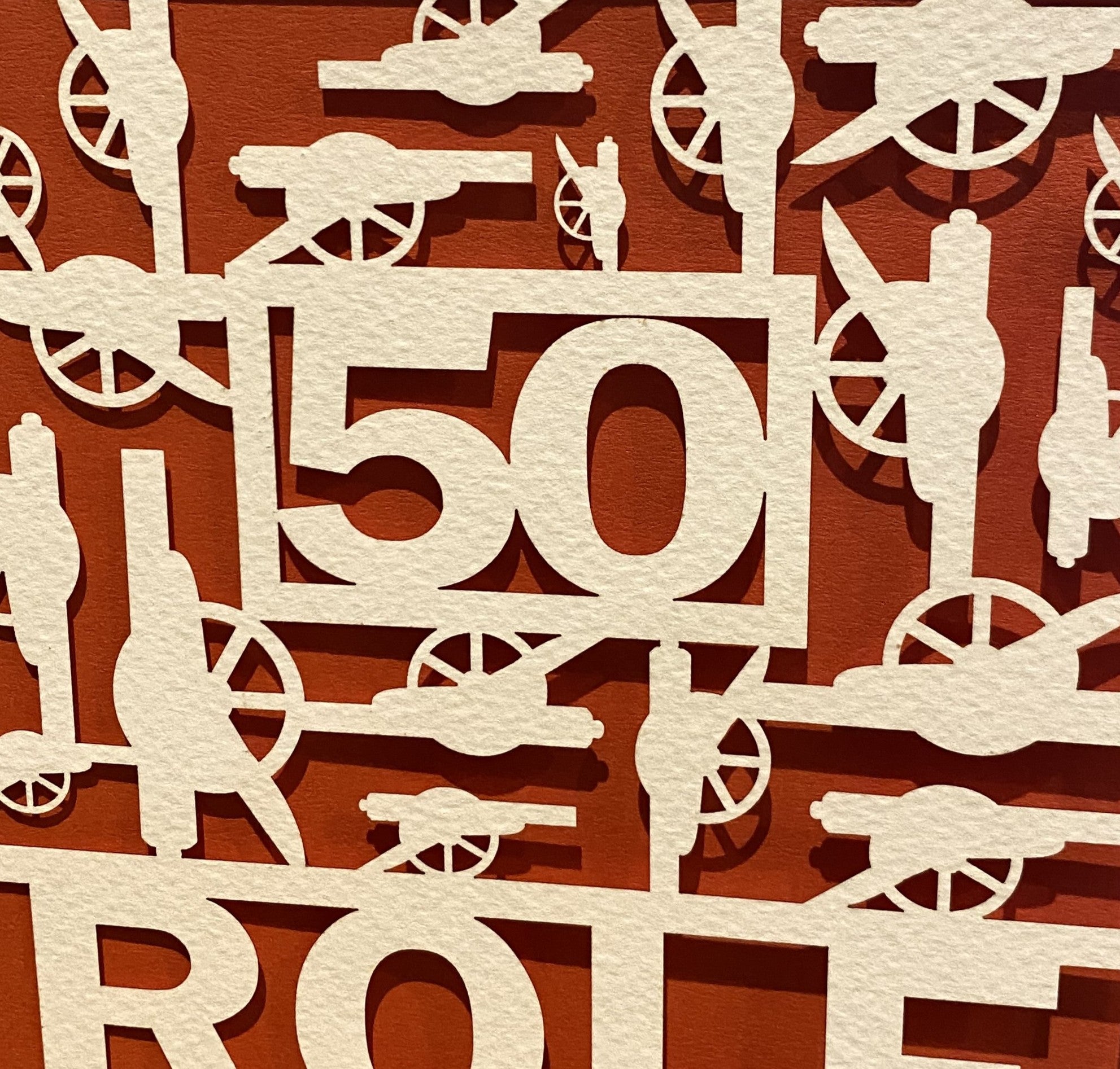 Close-up of intricate laser-cut papercut featuring football club logo design details

