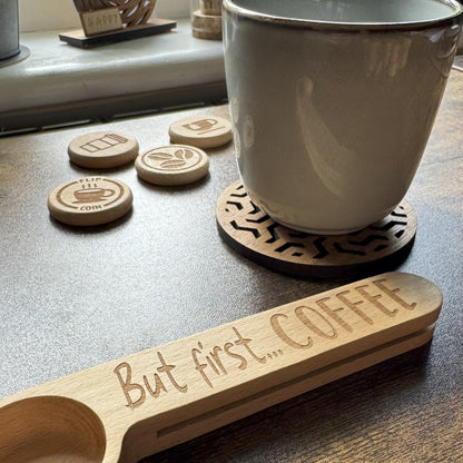 Engraved coffee spoon with mug  of coffee, with coins flipped in the background, styled for a playful and cosy beverage moment