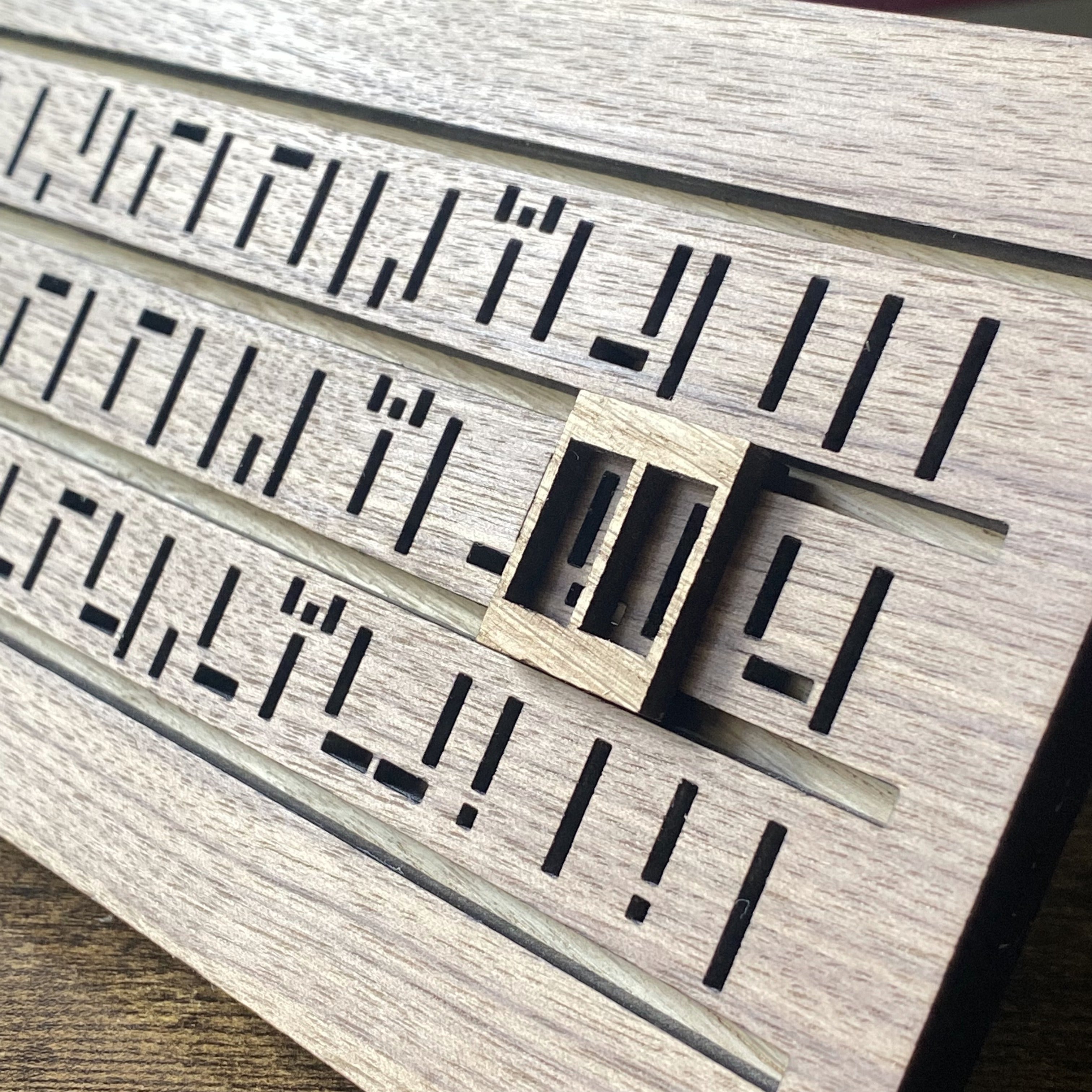 Close-up of cryptic wooden calendar featuring intricate engraved symbols