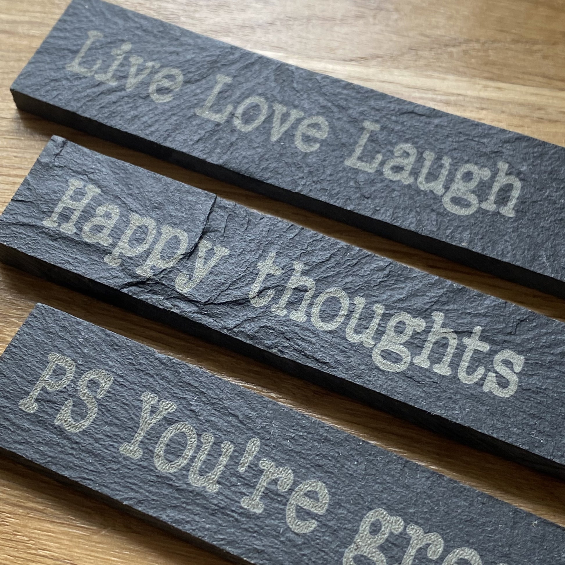Close up of slate plant marker with inspirational affirmation engraving