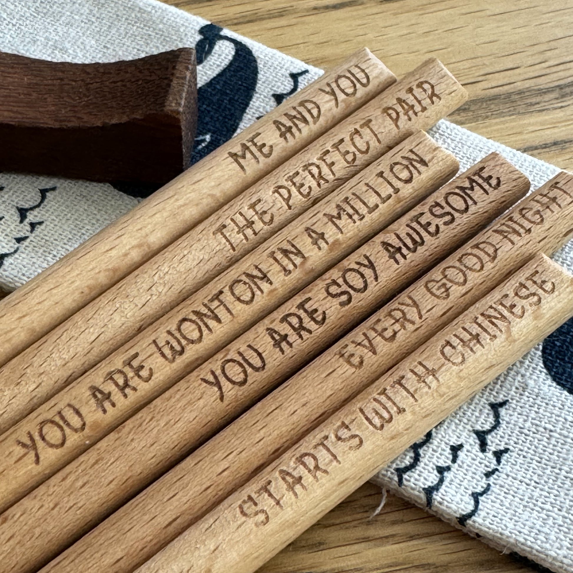 Selection of bamboo chopsticks with engraved sayings on display.