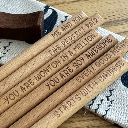 Selection of bamboo chopsticks with engraved sayings on display.