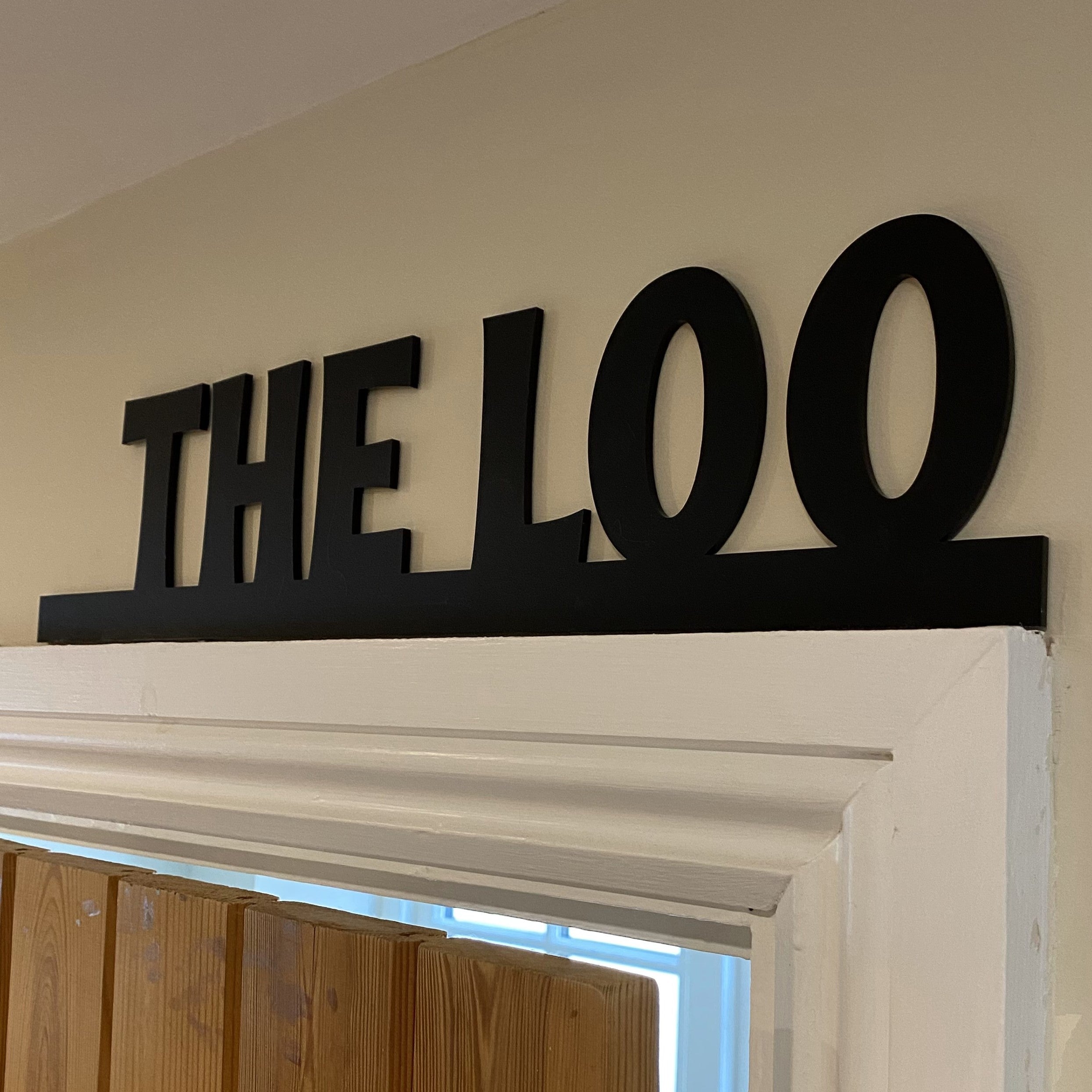 Fun black acrylic loo sign designed to fit above architrave, adding playful touch to interior