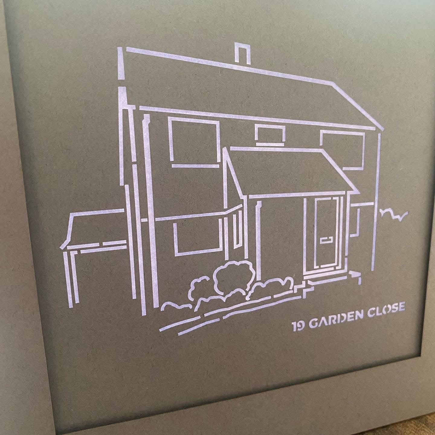 Intricate papercut of a house portrait created from a delicate line drawing design with backlight