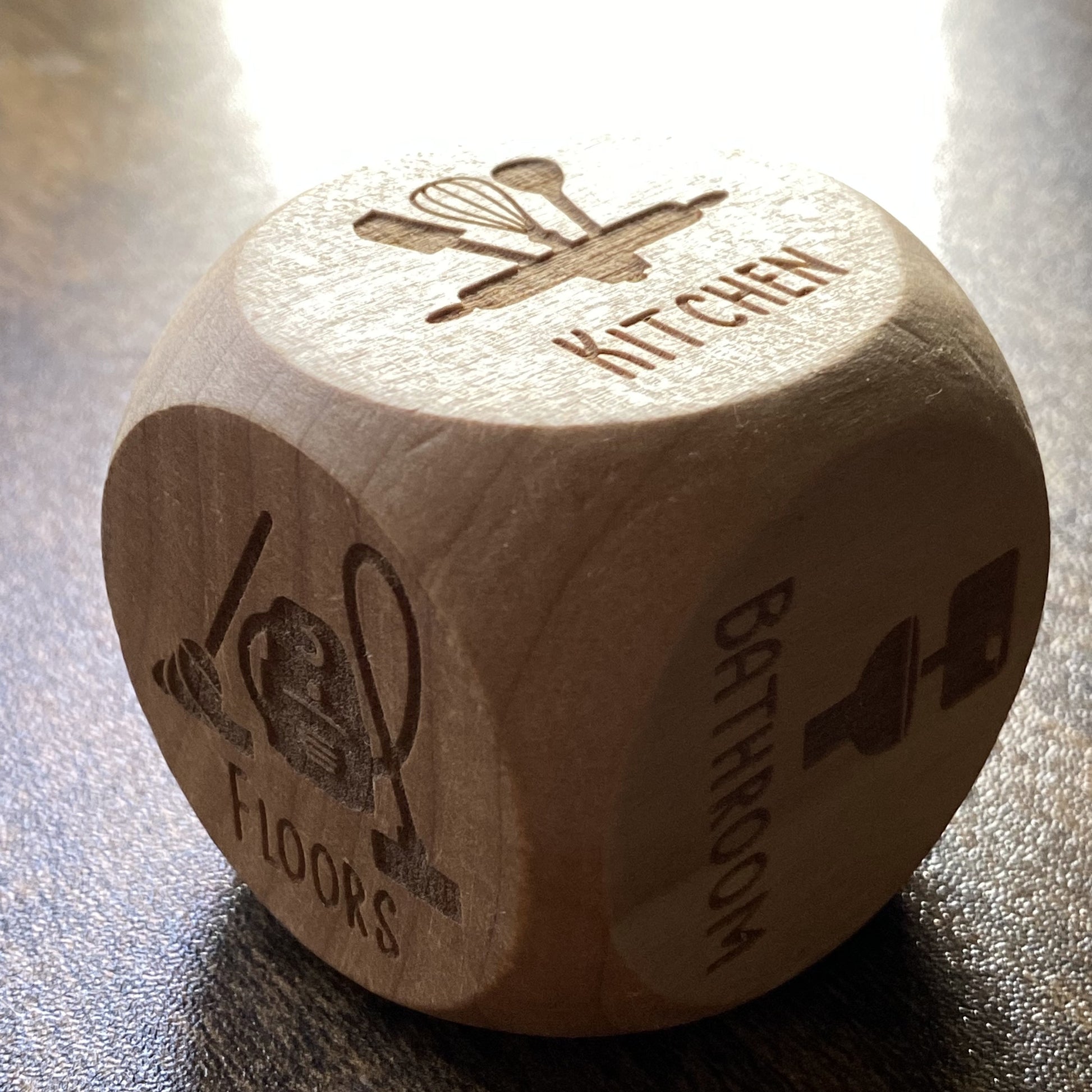 Engraved wooden dice for household chores with clear task labels, designed to make cleaning decisions fair and fun