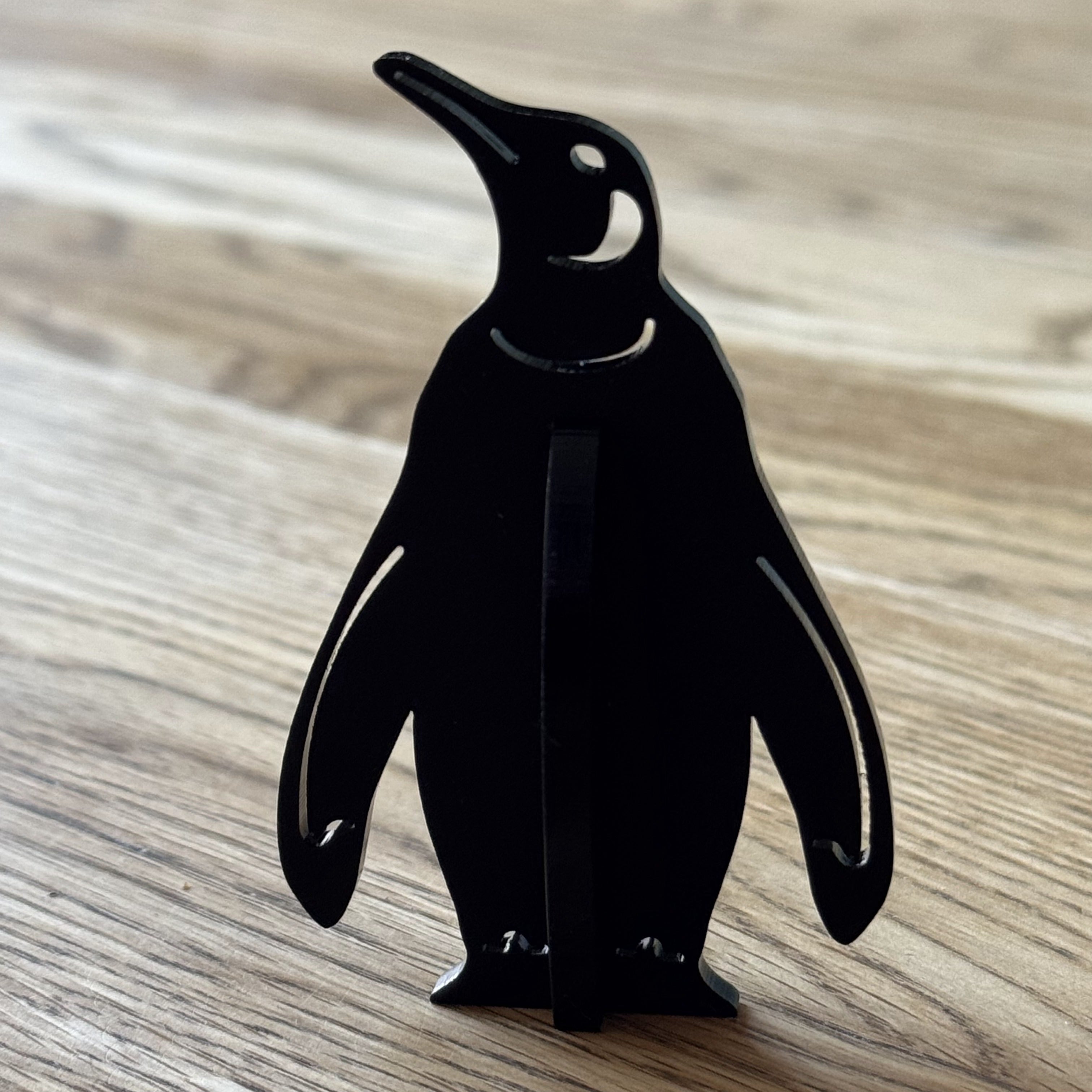 Detailed laser-cut acrylic penguin artwork with fine engraved features