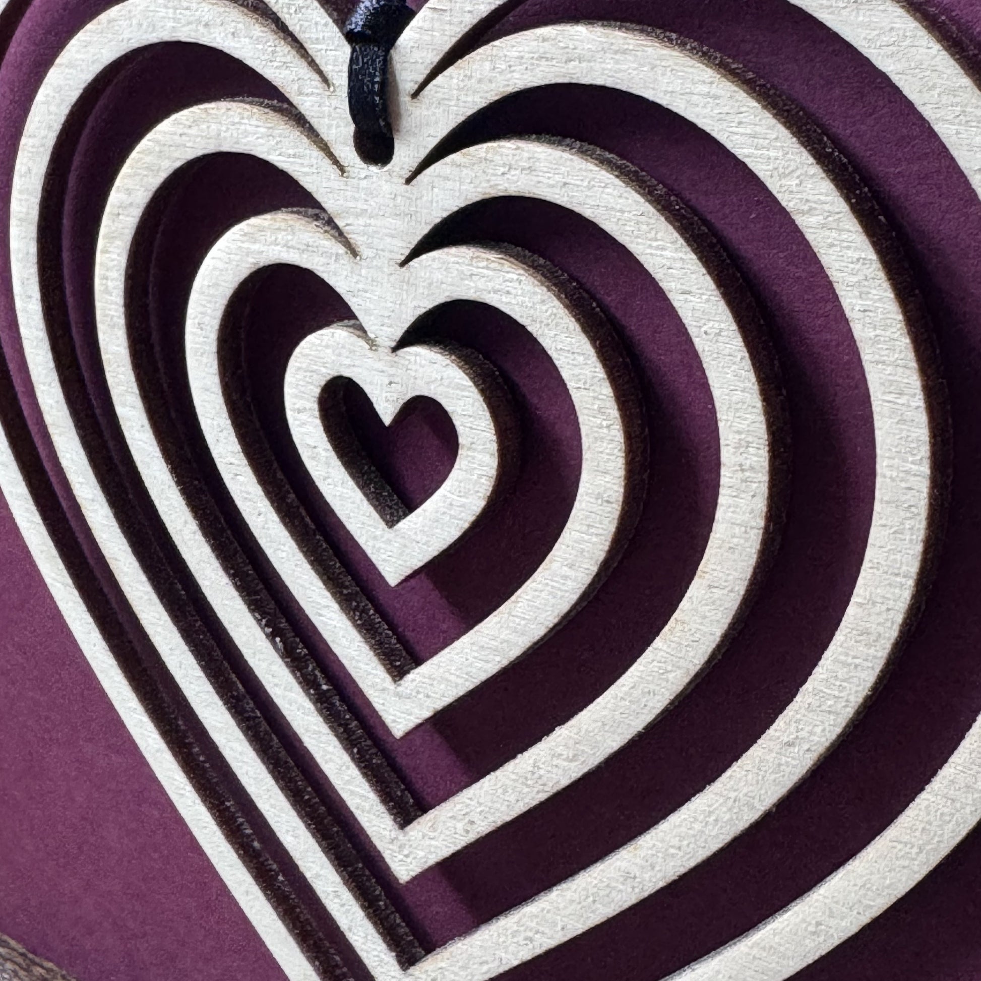 Angled close-up of Heart Keepsake Charm Card showing laser cut wooden charm, ribbon detail, and striking design