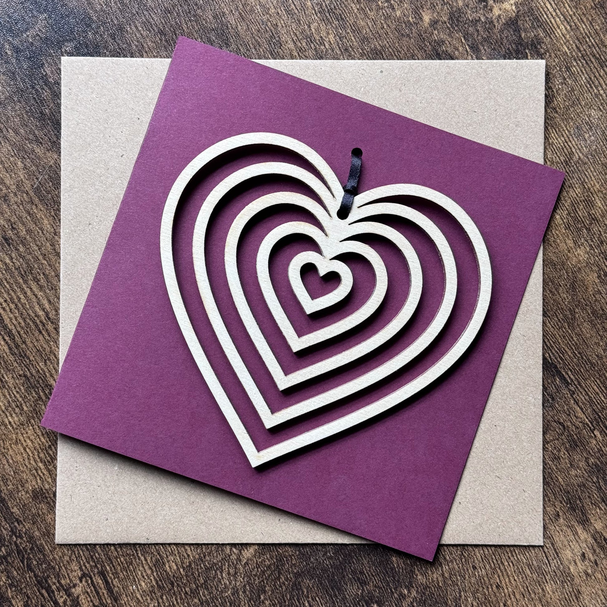 Top-down view of Keepsake Charm Card featuring a natural wooden heart charm with coordinating ribbon, elegantly displayed to show striking design.