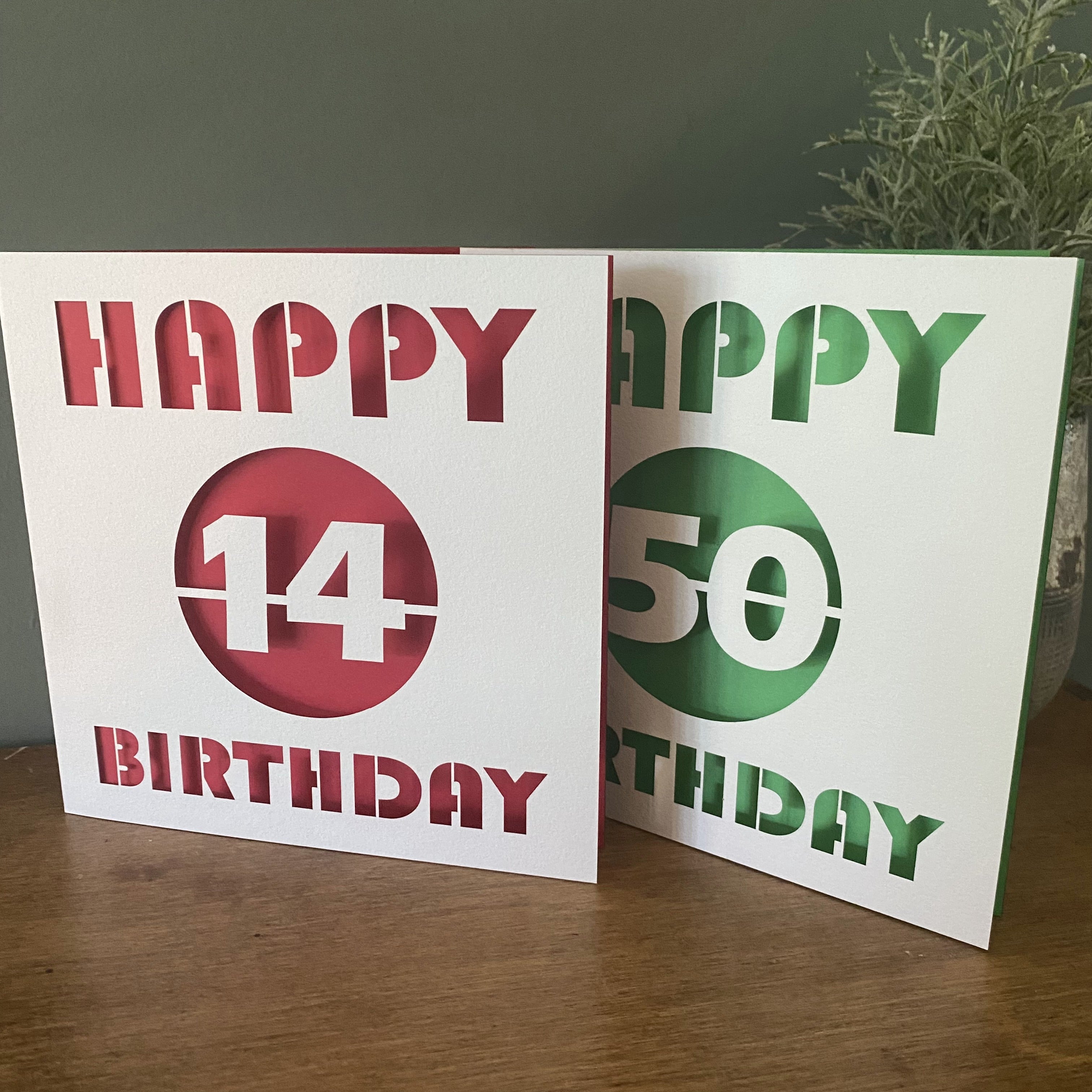 Laser cut paper birthday cards featuring number designs for milestone celebrations