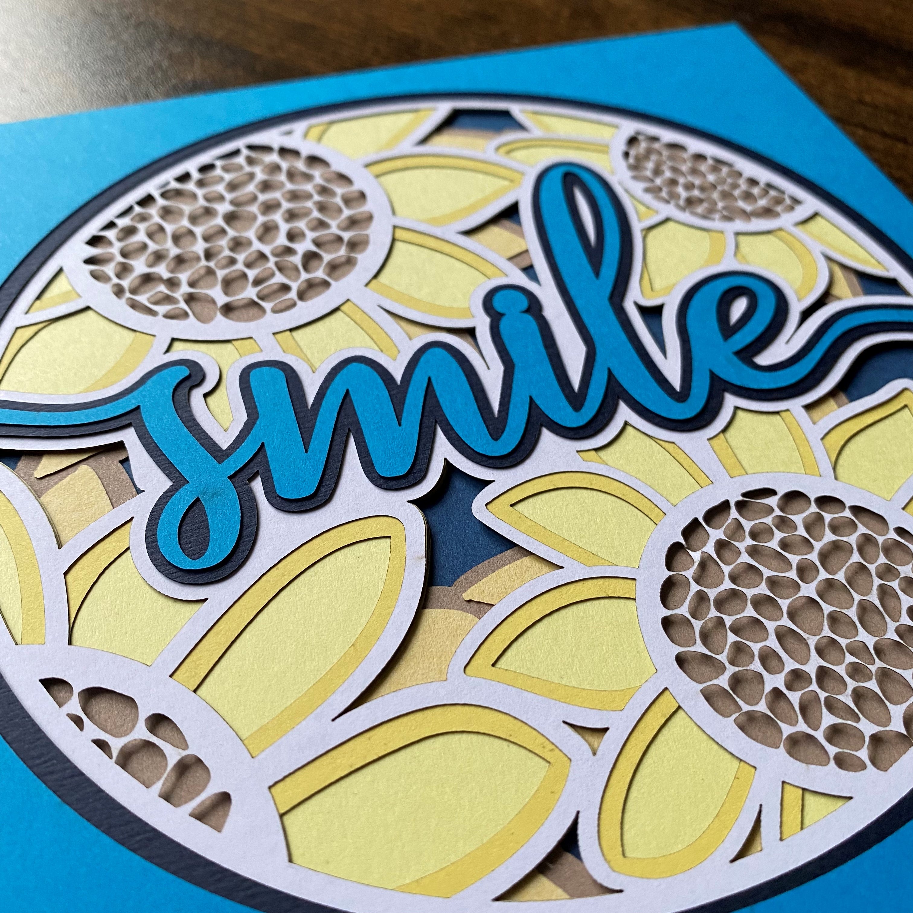 Layered delicate paper cut artwork featuring smile wording with sunflower detailing