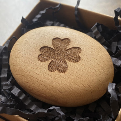 Wooden pocket pebble engraved with four-leaf clover – classic symbol of good fortune shown in gift box