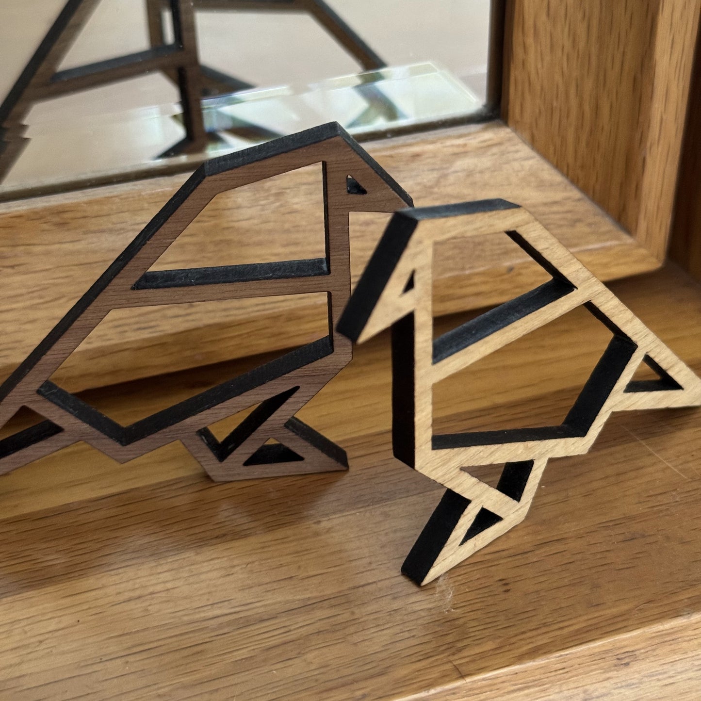 Contemporary walnut bird sculptures reflected in a mirror – elegant accent for modern homes