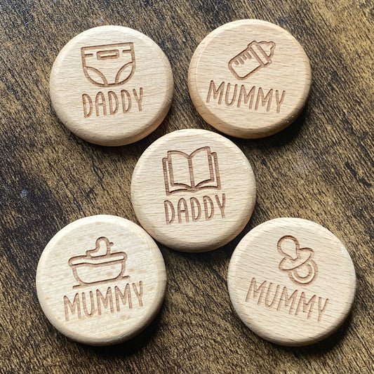 Top-down view of the five unique designs of the New Baby Duties Flip Coin Set, showcasing their detailed engravings