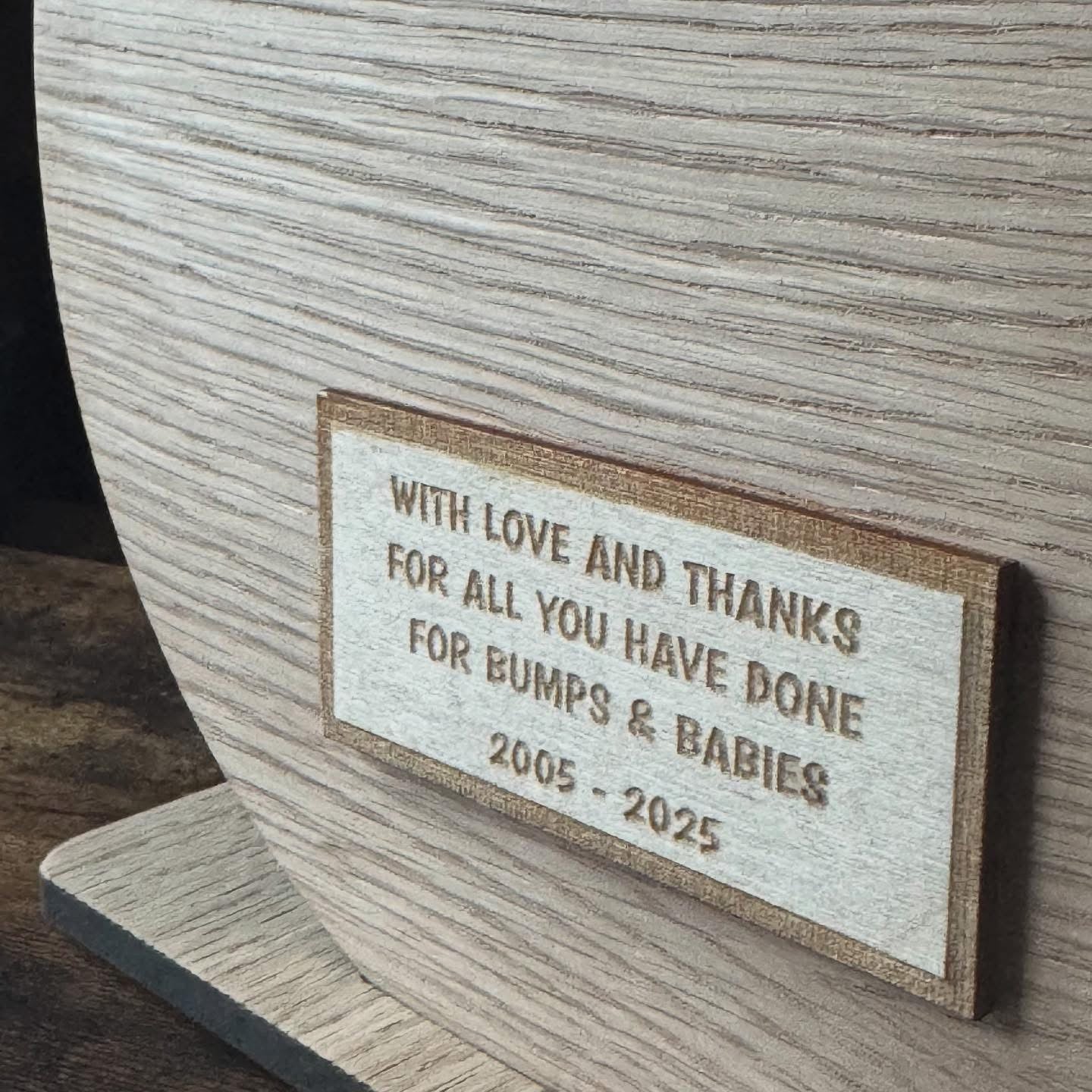 Close-up of personalised engraved dedication on the reverse of a bespoke oak presentation board award, showing custom detailing