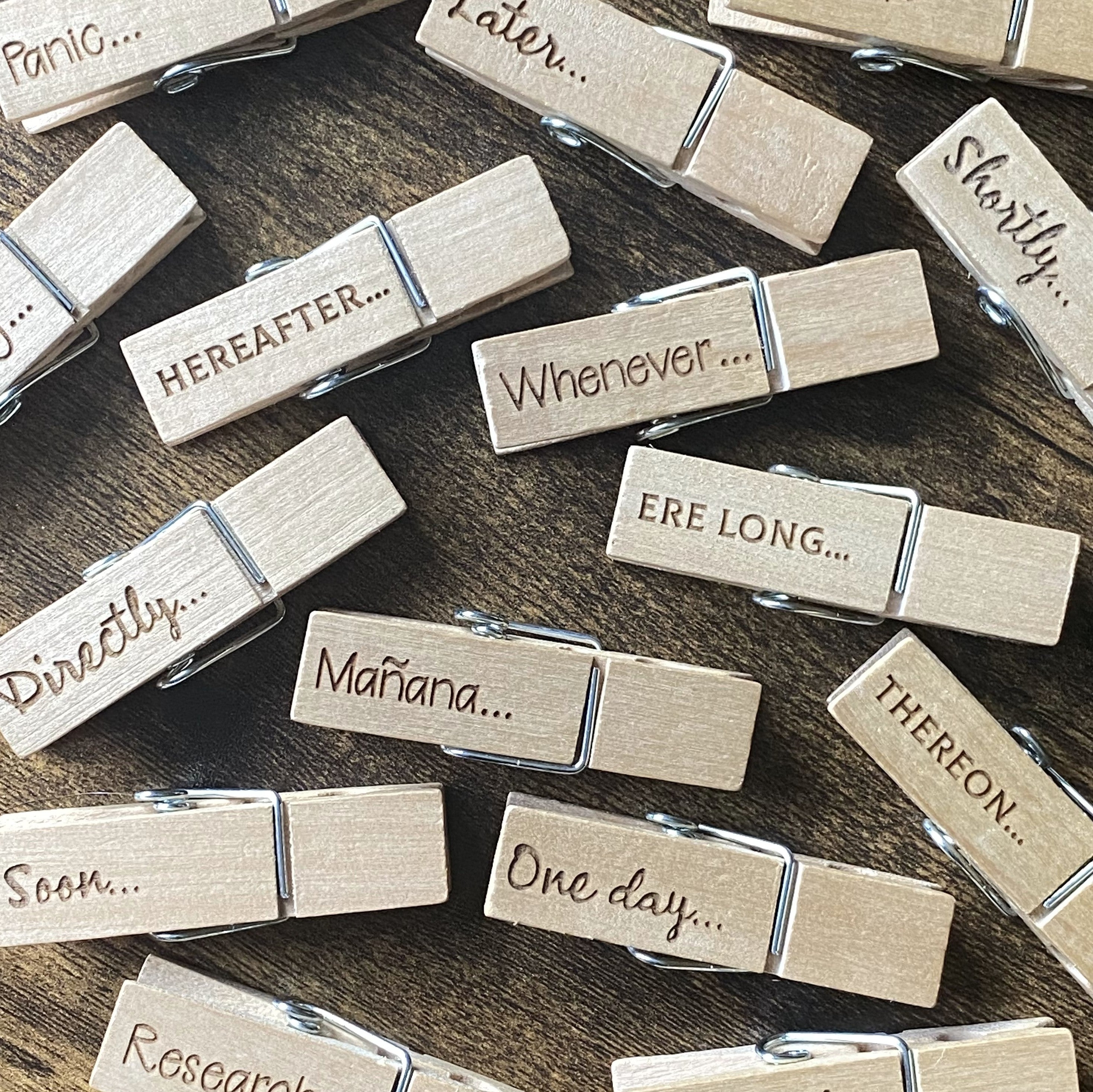 Trios of engraved wooden desk pegs from the Procrastination Range scattered on a desk, each featuring witty personality-themed designs for playful organisation.