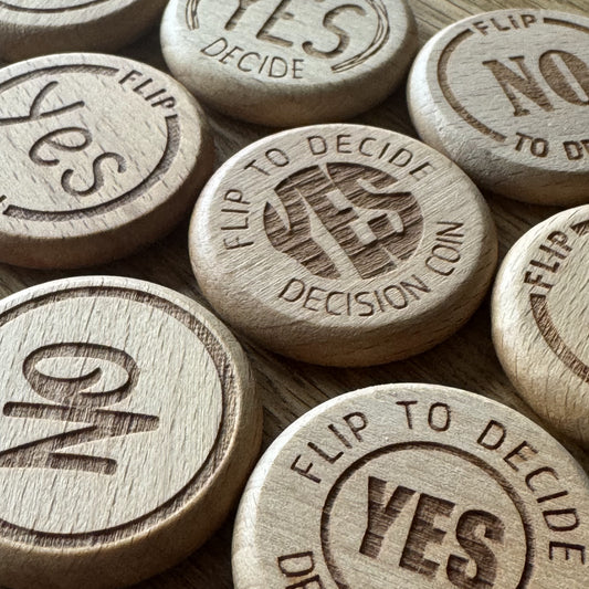 Wooden decision coins with 'Yes' and 'No' options on a wooden surface