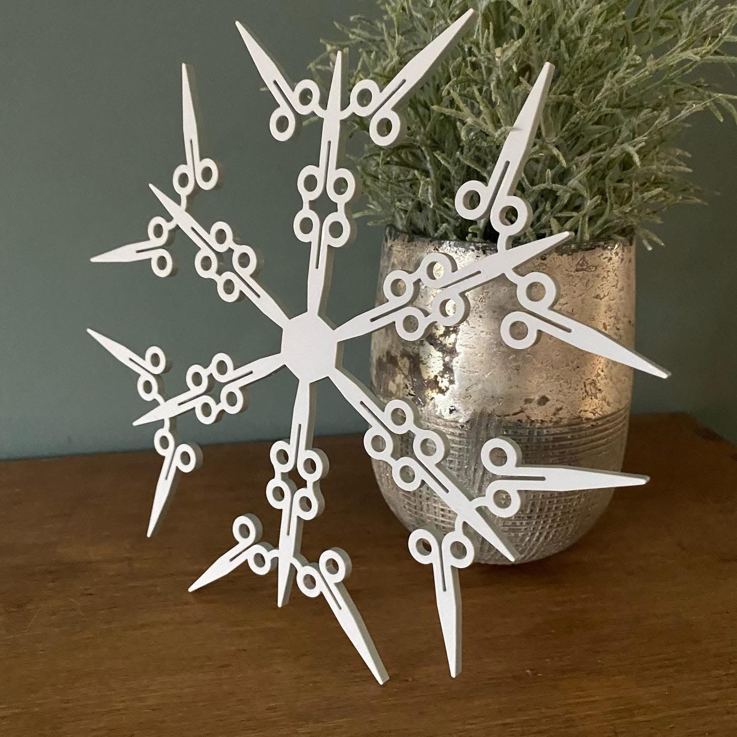 Intricate laser cut snowflake decoration featuring tool-themed designs for craft or trade gifting