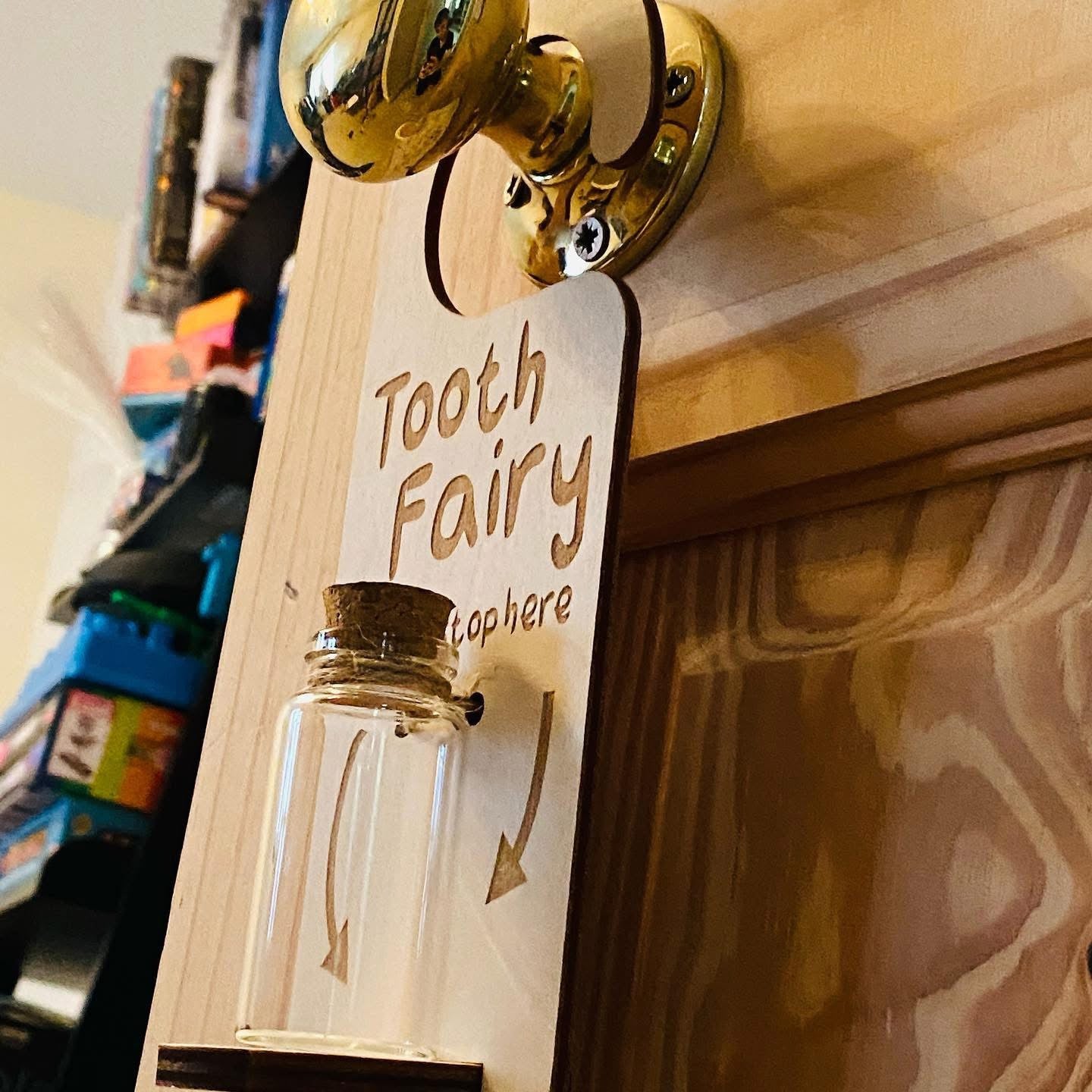 Wooden engraved tooth fairy hanger with charm collection jar displayed on bedroom door